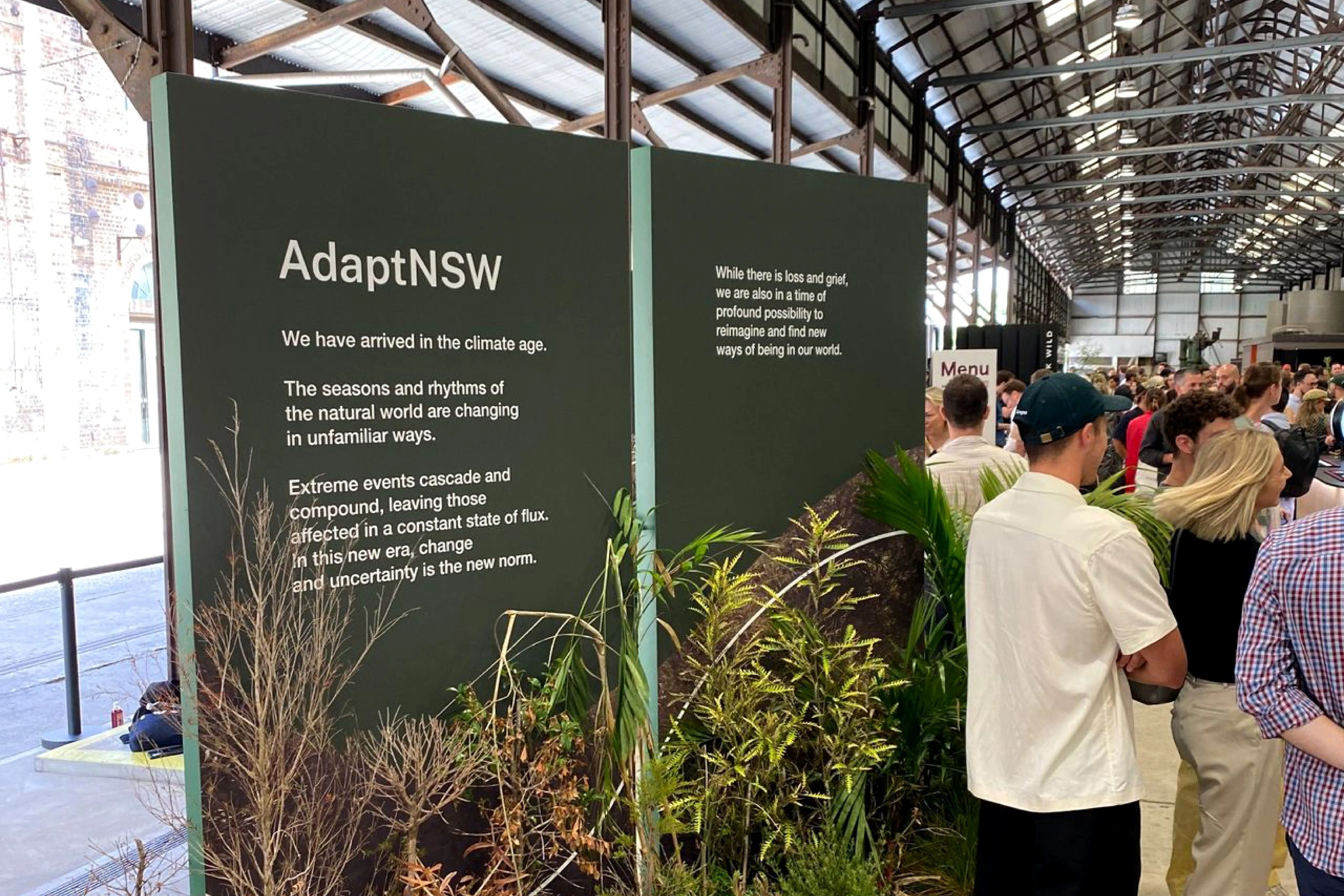 Attendees gathering beside an AdaptNSW installation showcasing climate-change messaging at Purpose Conference 2023.
