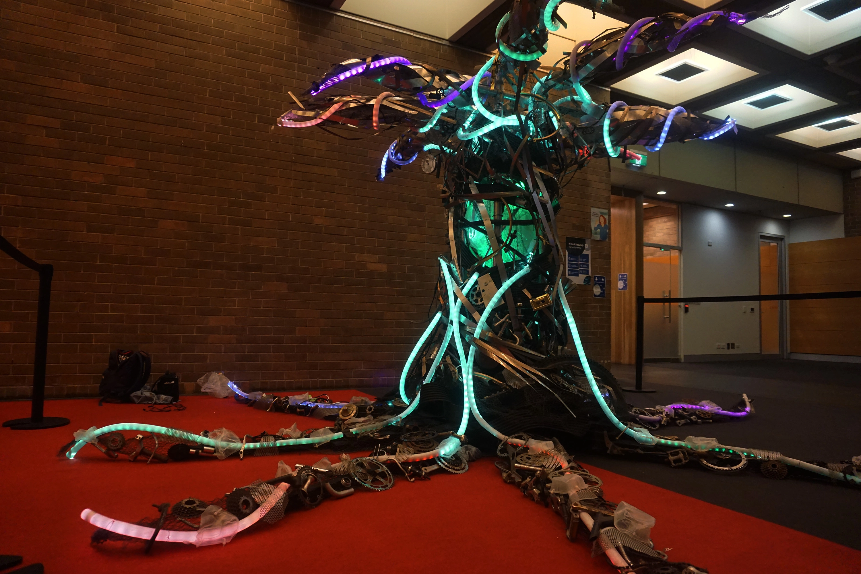 A glowing, branching light sculpture installed indoors, showing organic neon-like tendrils that illustrate the project’s exploration of natural patterns.