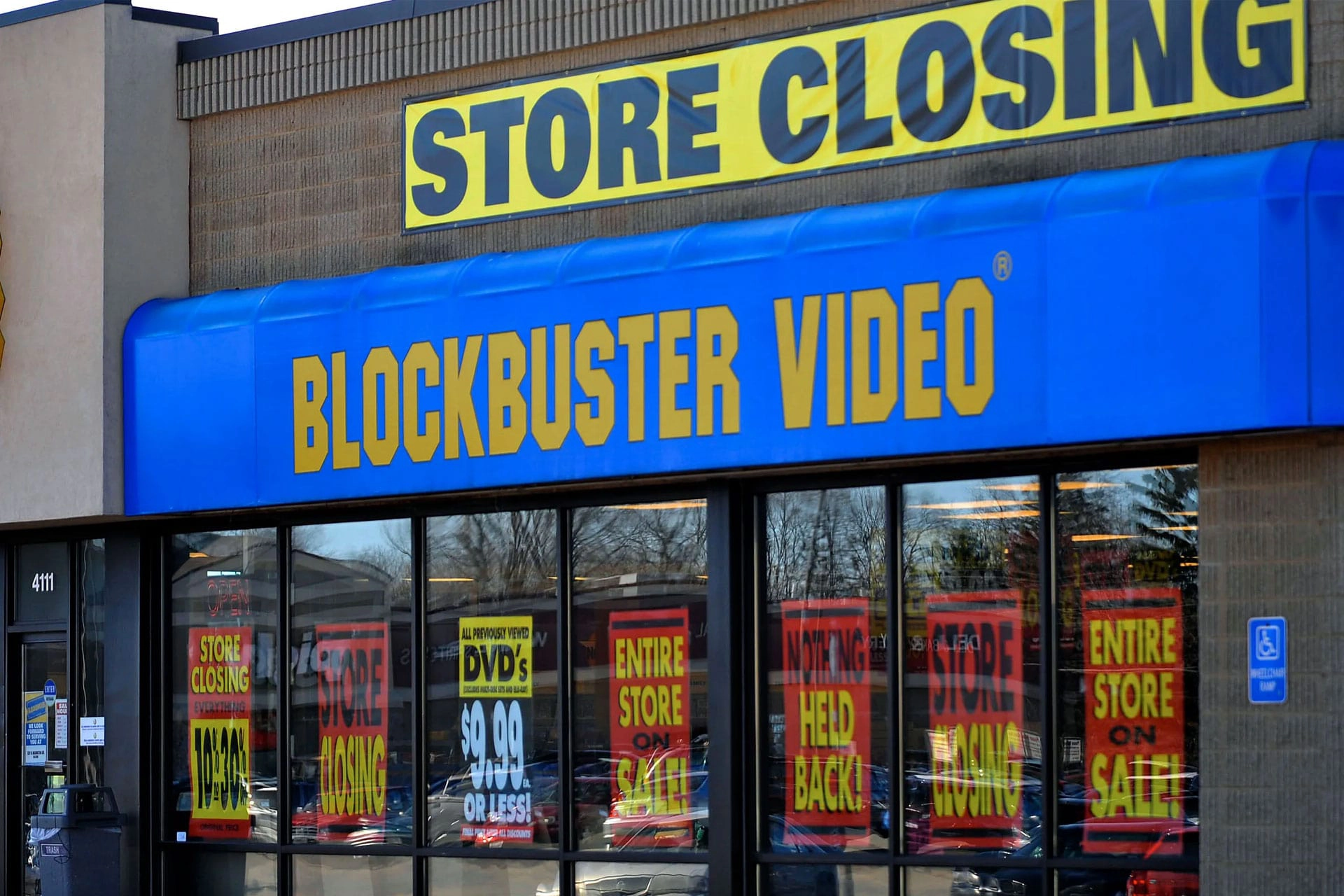 Blockbuster Video storefront with large ‘Store Closing’ signs in the windows.