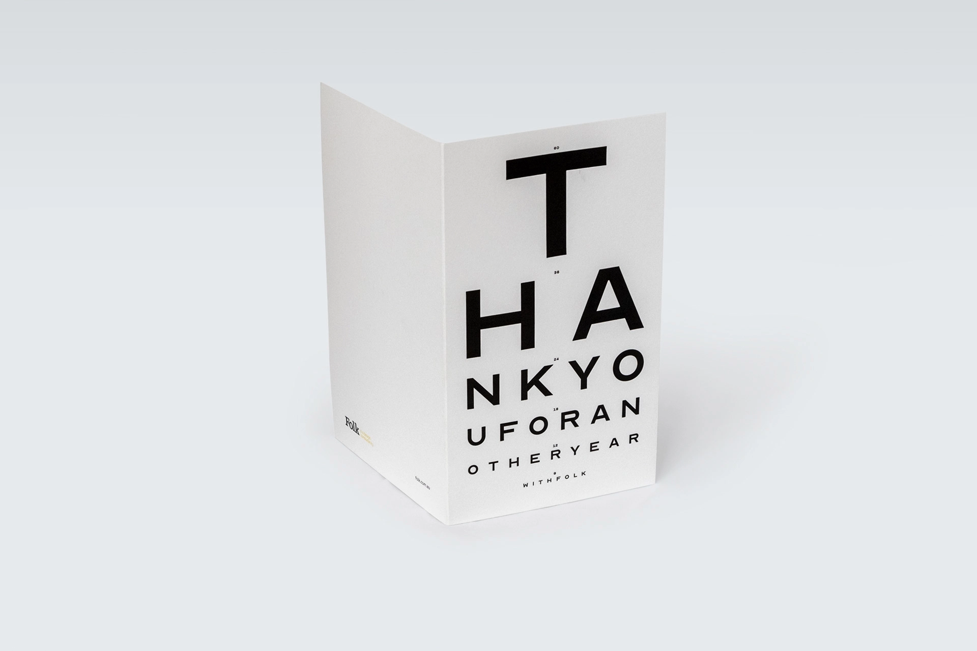 Folded card standing partly open, showing the eye-test message on the cover.