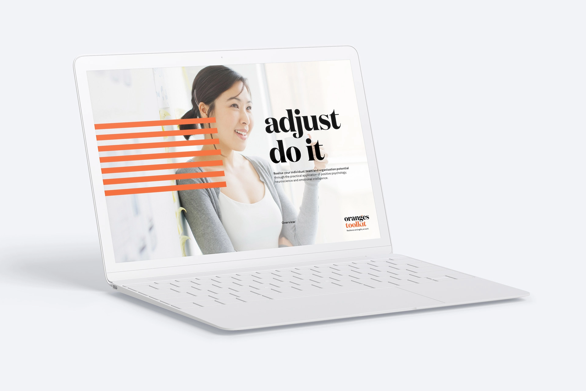 A laptop displaying Oranges Toolkit training material featuring the headline “adjust do it” beside a smiling participant.