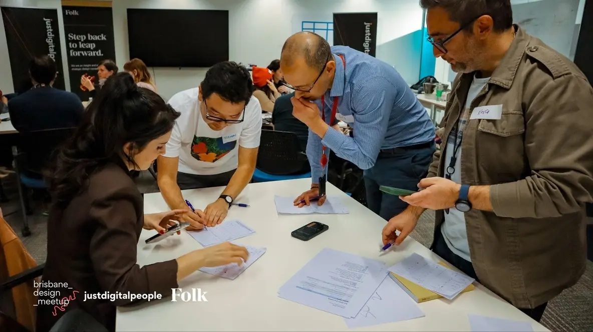 Collaborating around a table during a design meetup workshop.