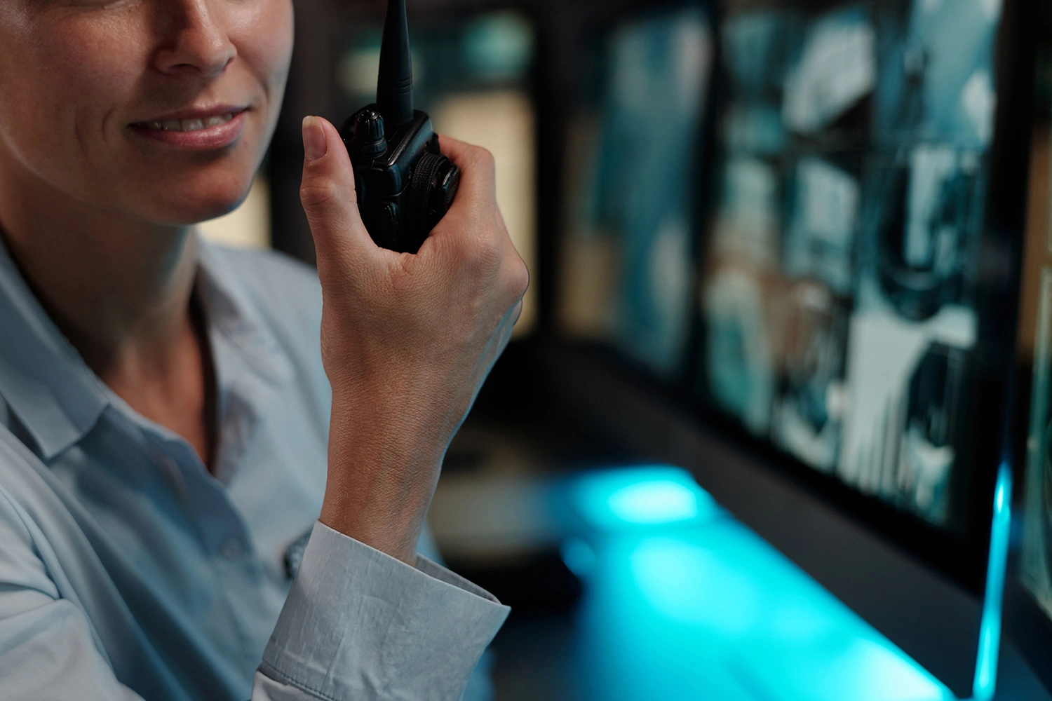 Een meldkamer met een beveiliger die praat in een walkie-talkie