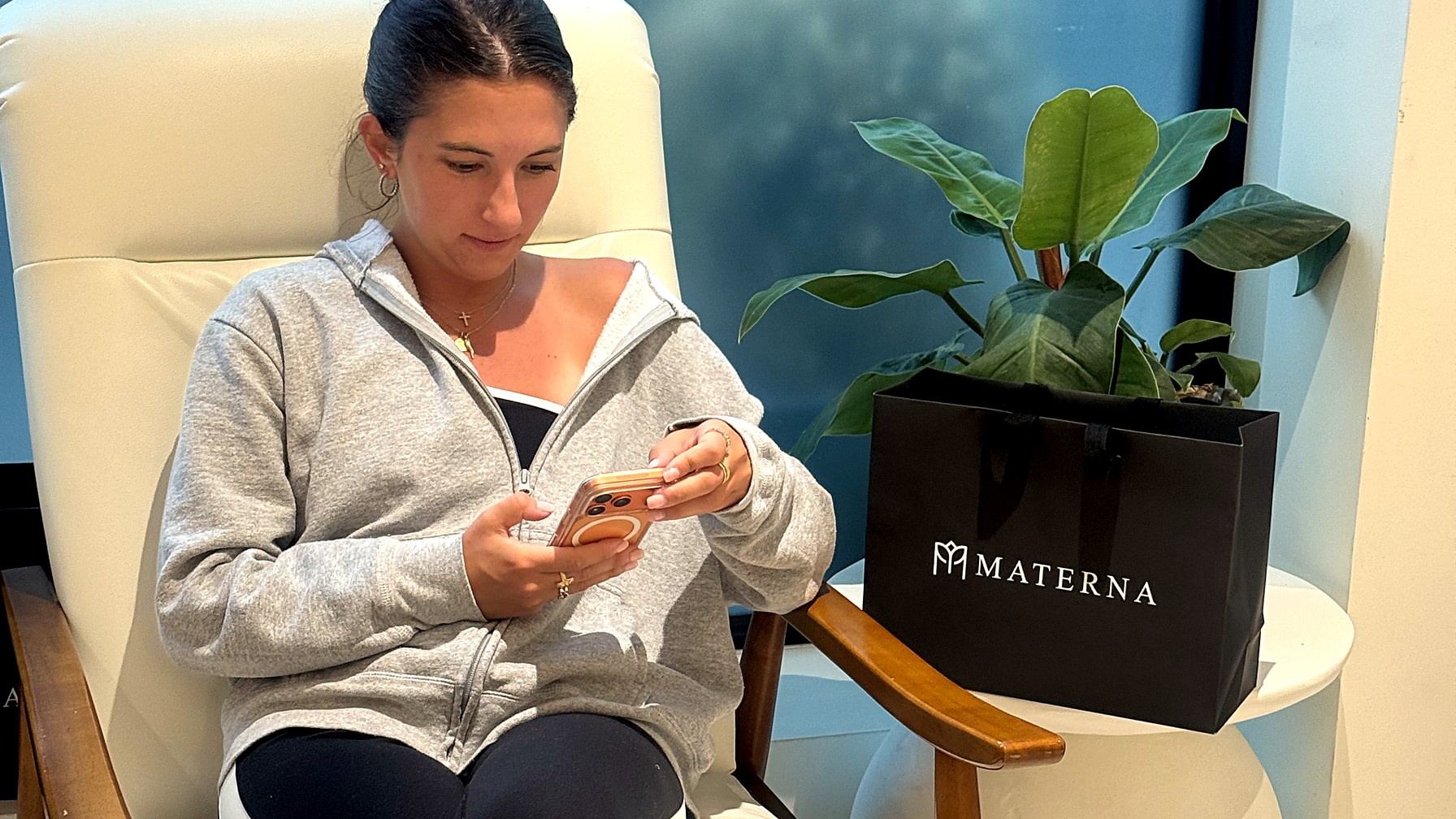 Woman waiting comfortably in an armchair in the Materna West Village office waiting area