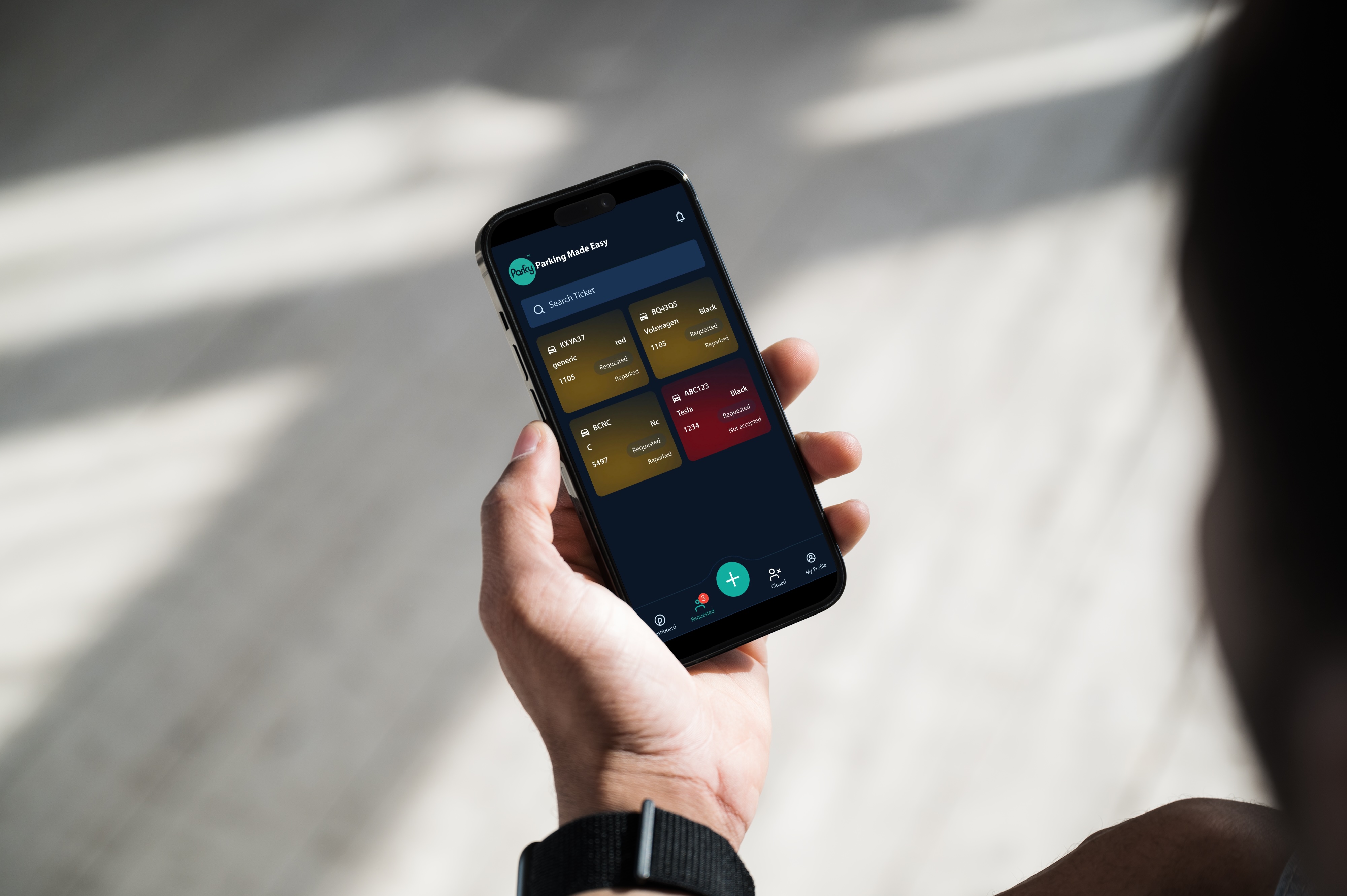 Person holding a smartphone displaying a parking management app with vehicle tickets and status updates.