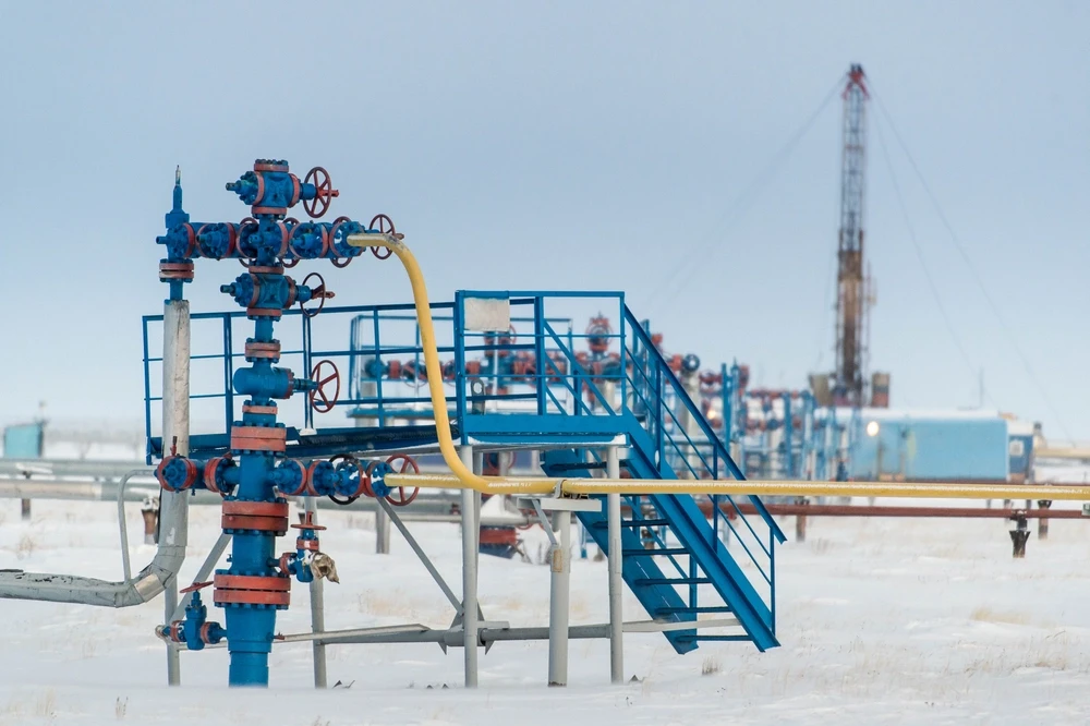 Équipements de tête de puits de pétrole et de gaz installés dans un champ isolé et enneigé.