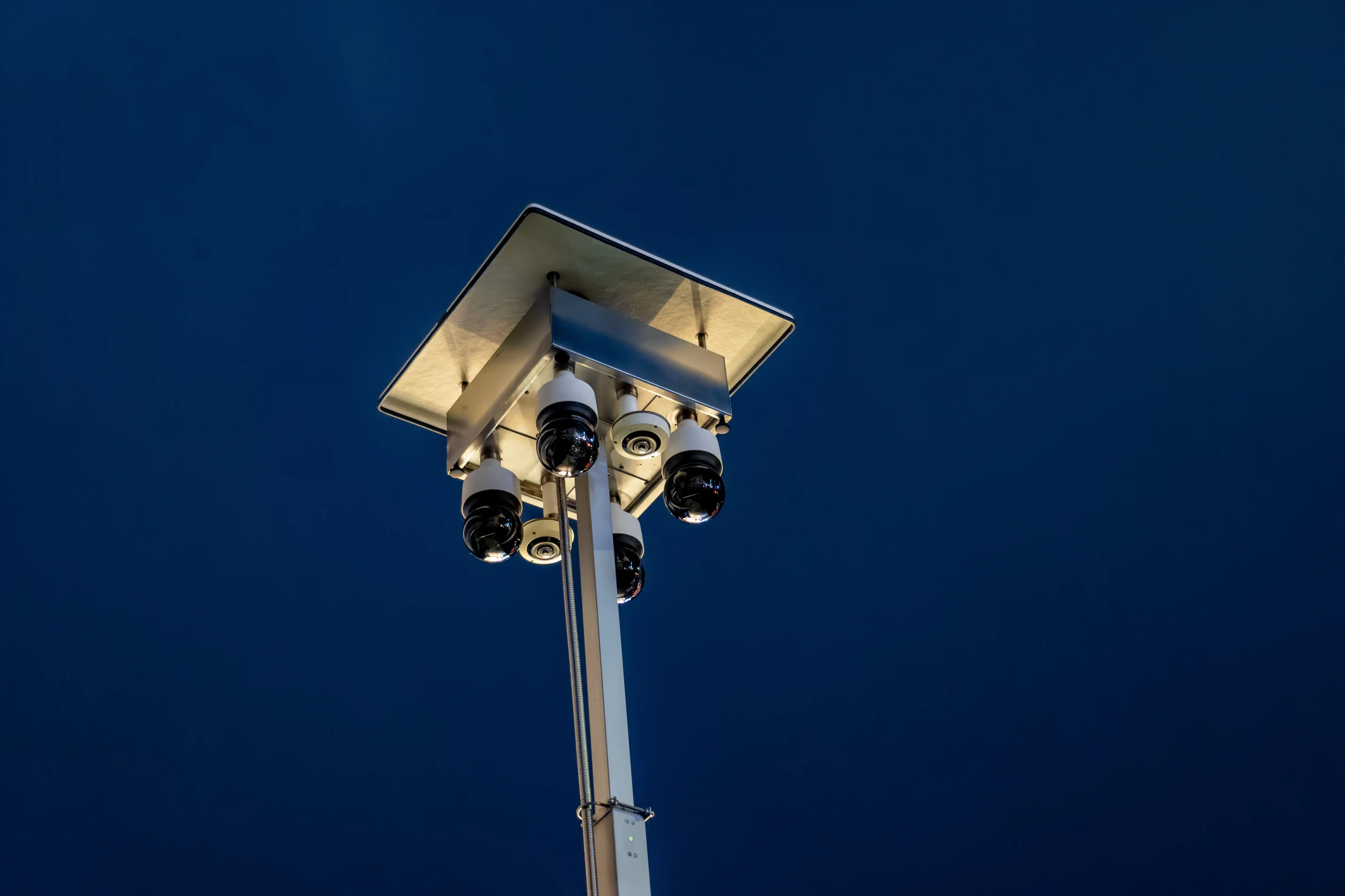 Surveillance camera system mounted on a pole for continuous site monitoring at night.