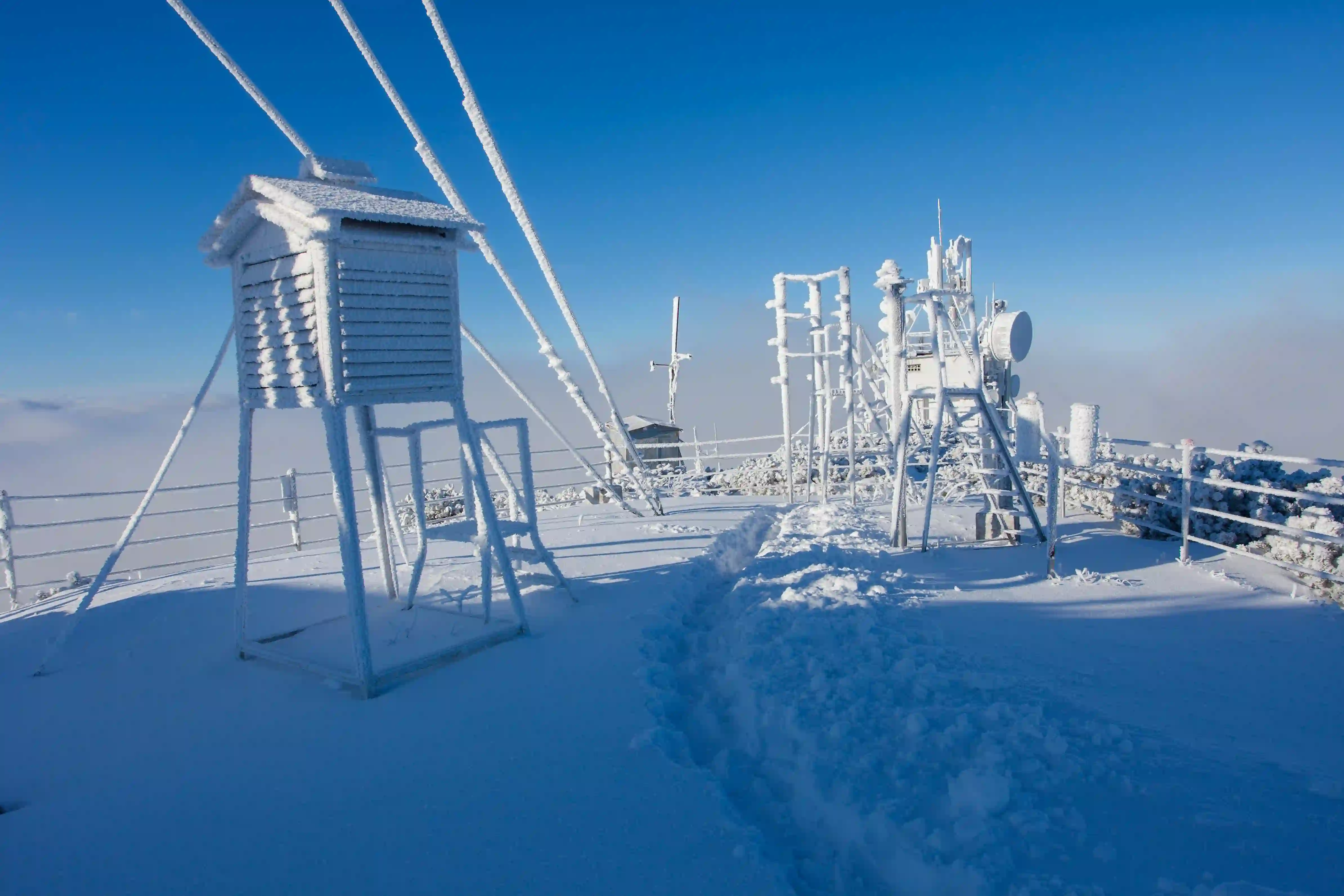 Snow-covered remote monitoring and communication equipment operating in harsh winter conditions.