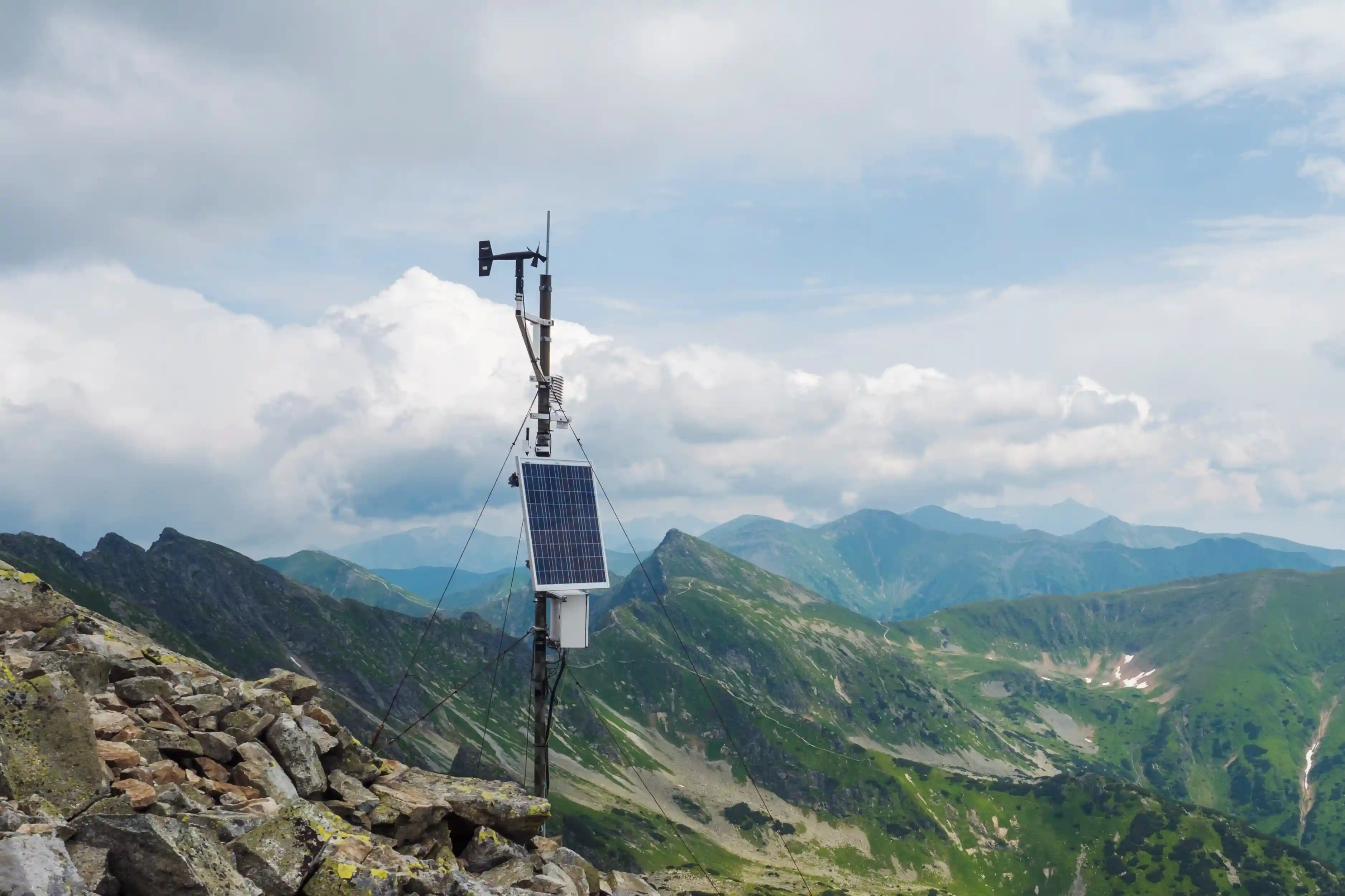 Remote weather monitoring station with a solar panel installed in the mountains.