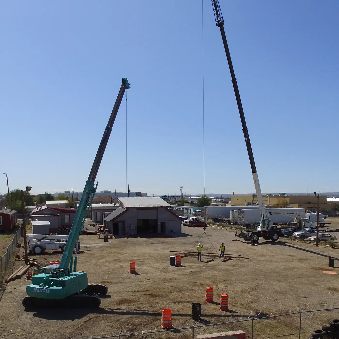 Two telescopic cranes set up in a training yard for operator certification practice.