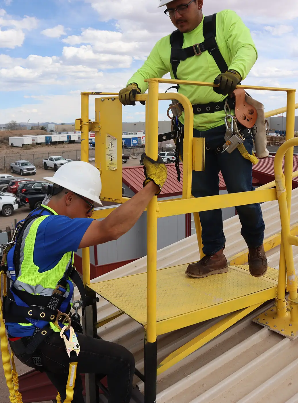 Worker in safety harness climbing with supervision during accredited fall protection training session.