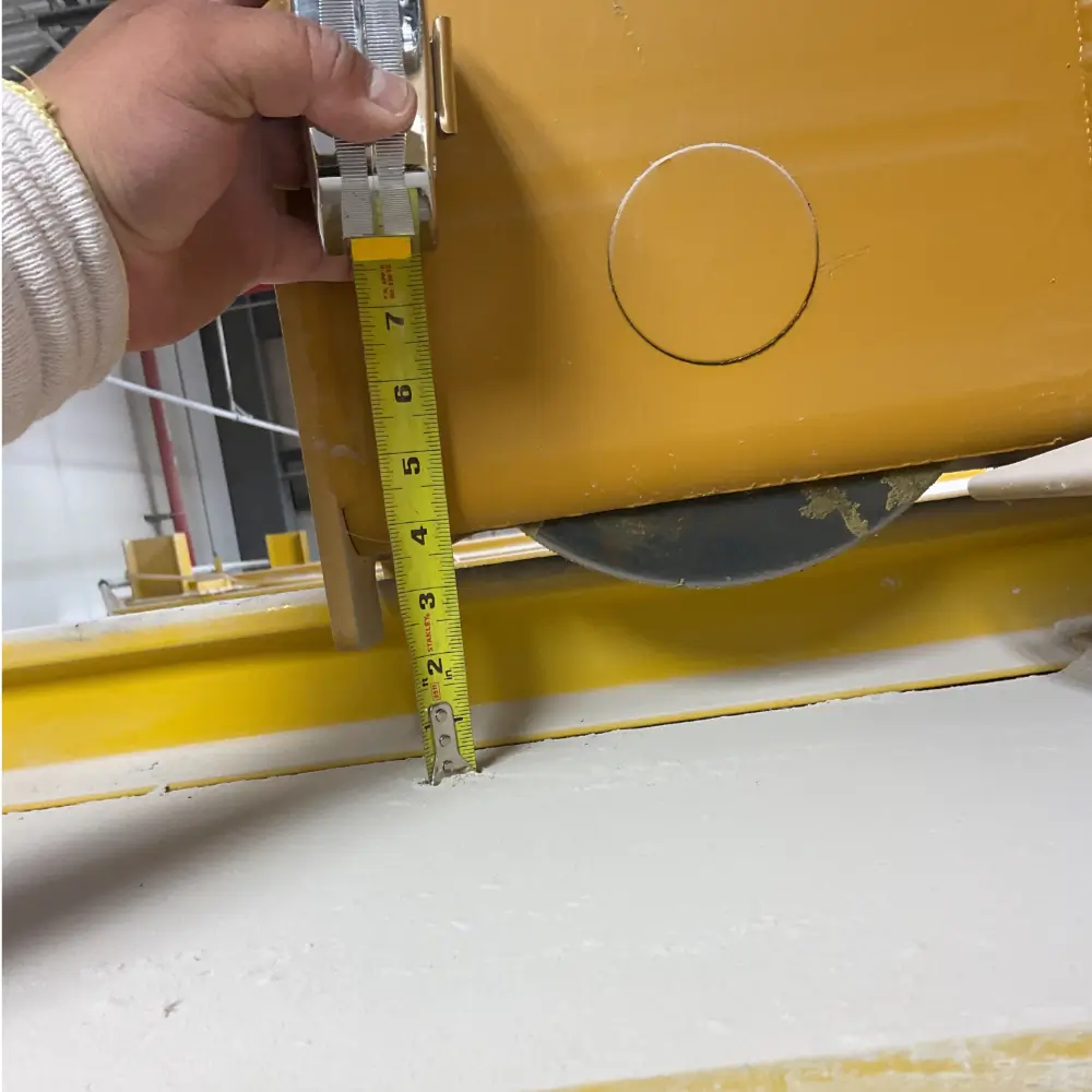 Technician measuring clearance on an overhead crane beam during safety inspection