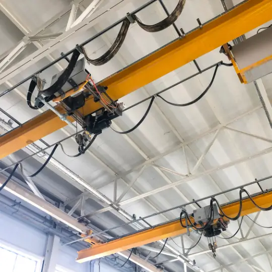 Overhead crane system inside industrial facility used for operator training and equipment inspection.
