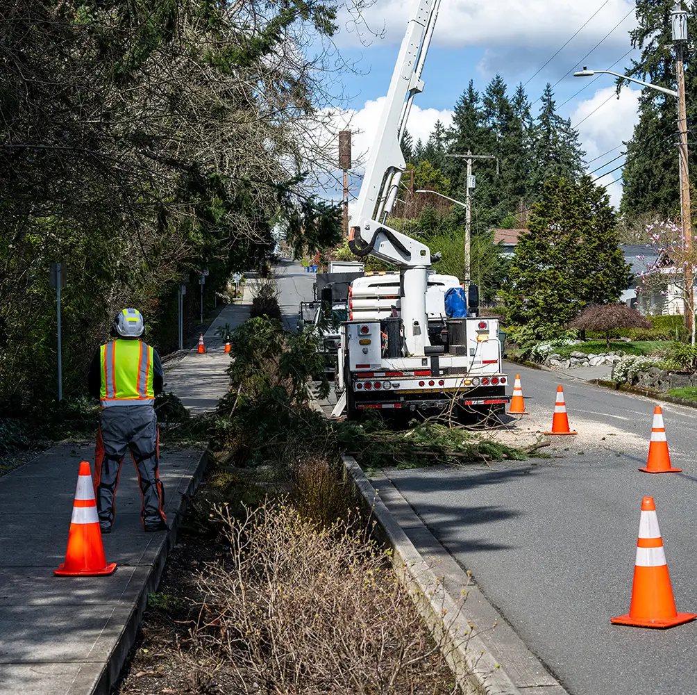 Safety inspector monitoring bucket truck operations during field training for elevated work safety.