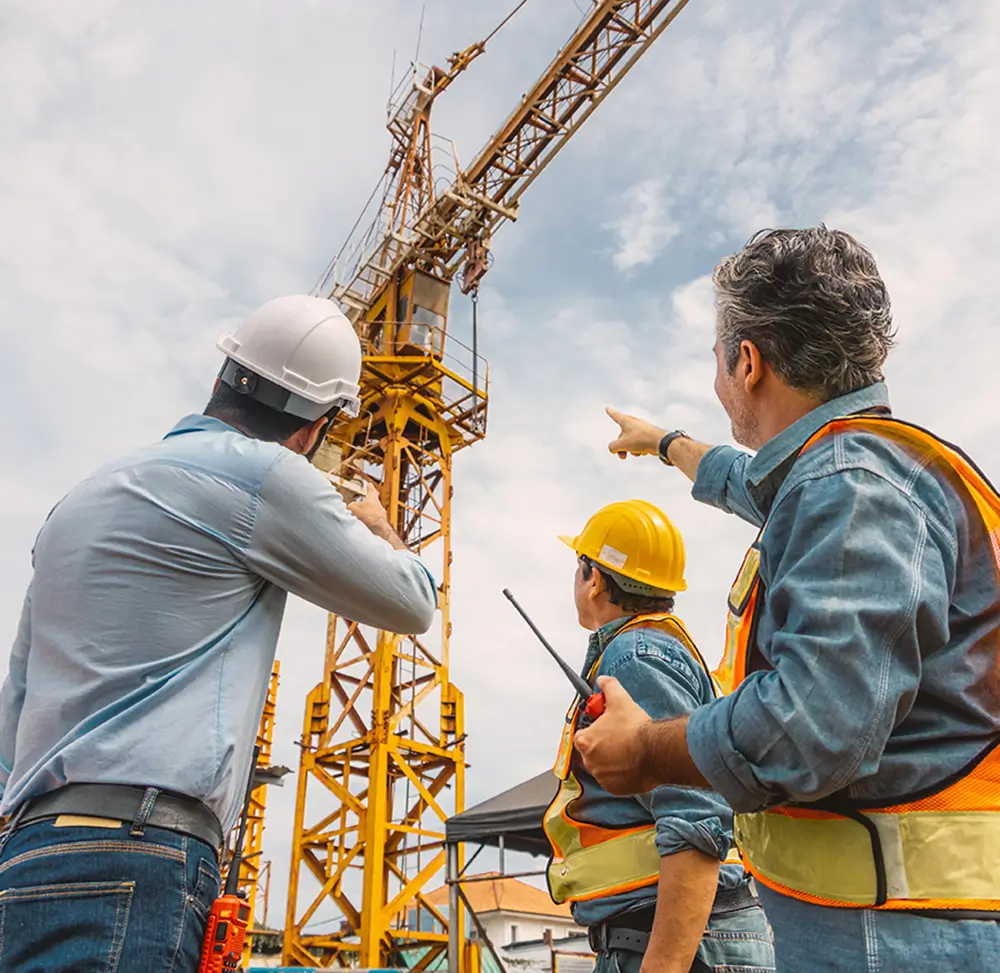 Safety consultants conducting crane risk assessment and management planning on an active construction site.