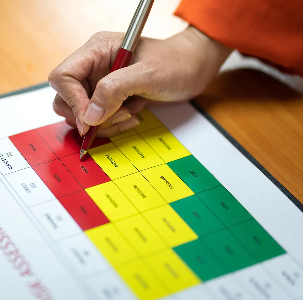 Close-up of safety inspector marking a risk assessment matrix during a due diligence and safety evaluation process.