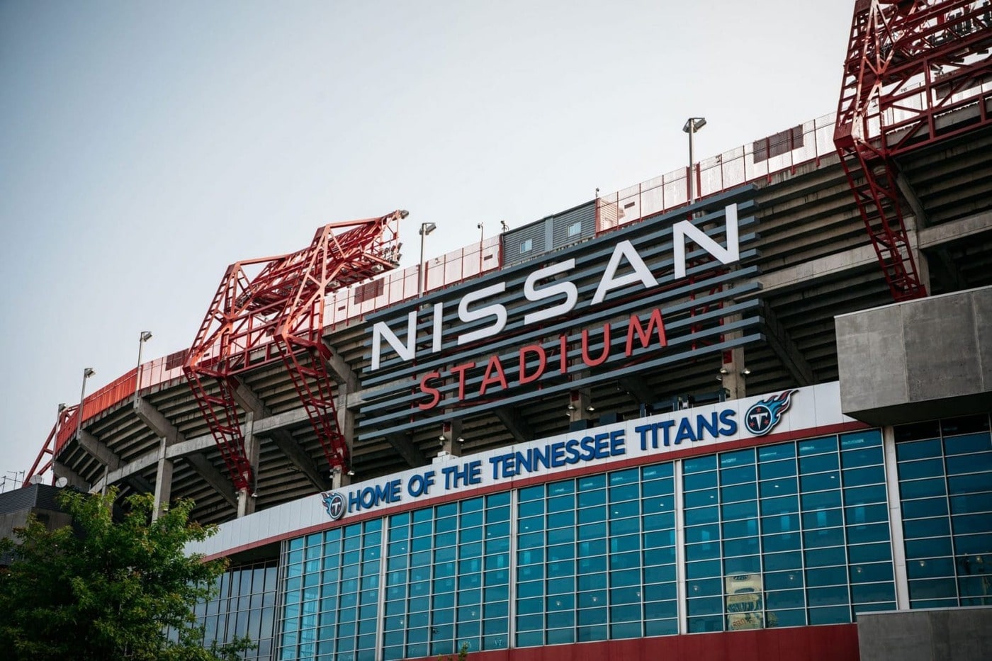 Exterior view of Nissan Stadium, home of the Tennessee Titans, showing large signage and stadium structure with red framework.