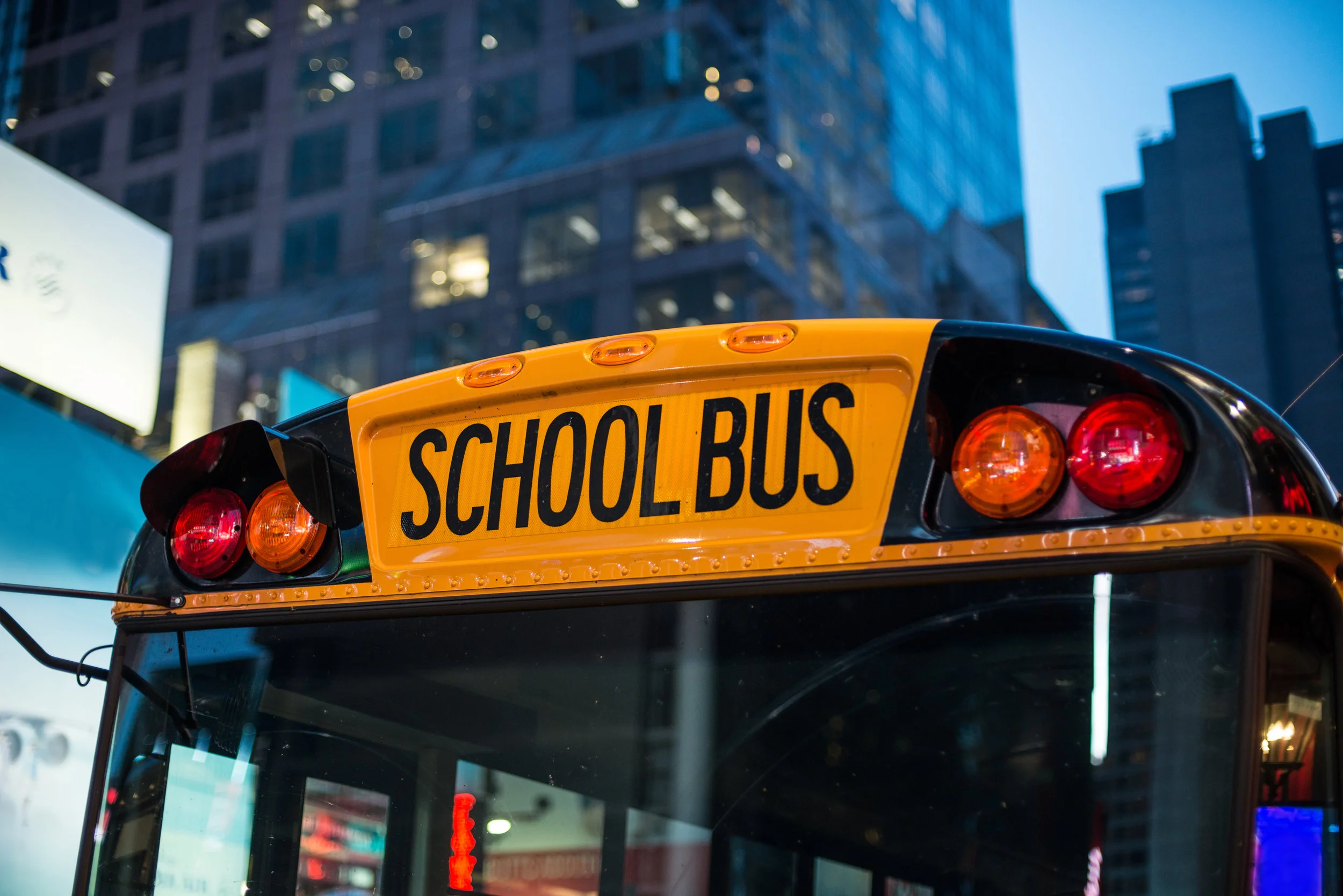  Image:  A school bus drives through the city at night.  