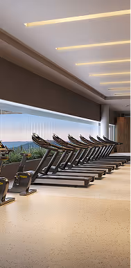 Esteira ergométrica alinhada em uma academia moderna com grandes janelas e vista para área verde.