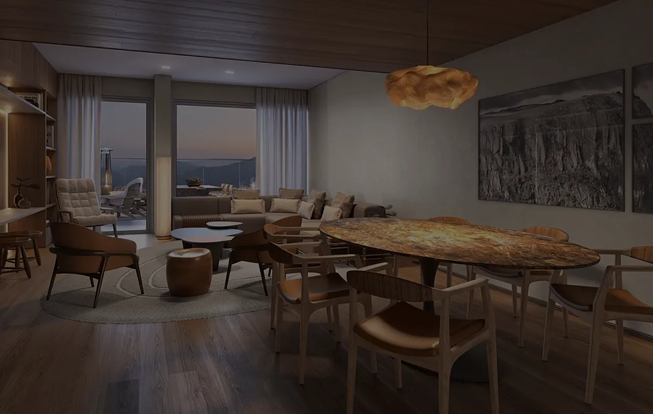 Sala de estar e jantar moderna com mesa de madeira oval, cadeiras, sofá cinza, poltronas e vista para montanhas ao pôr do sol.