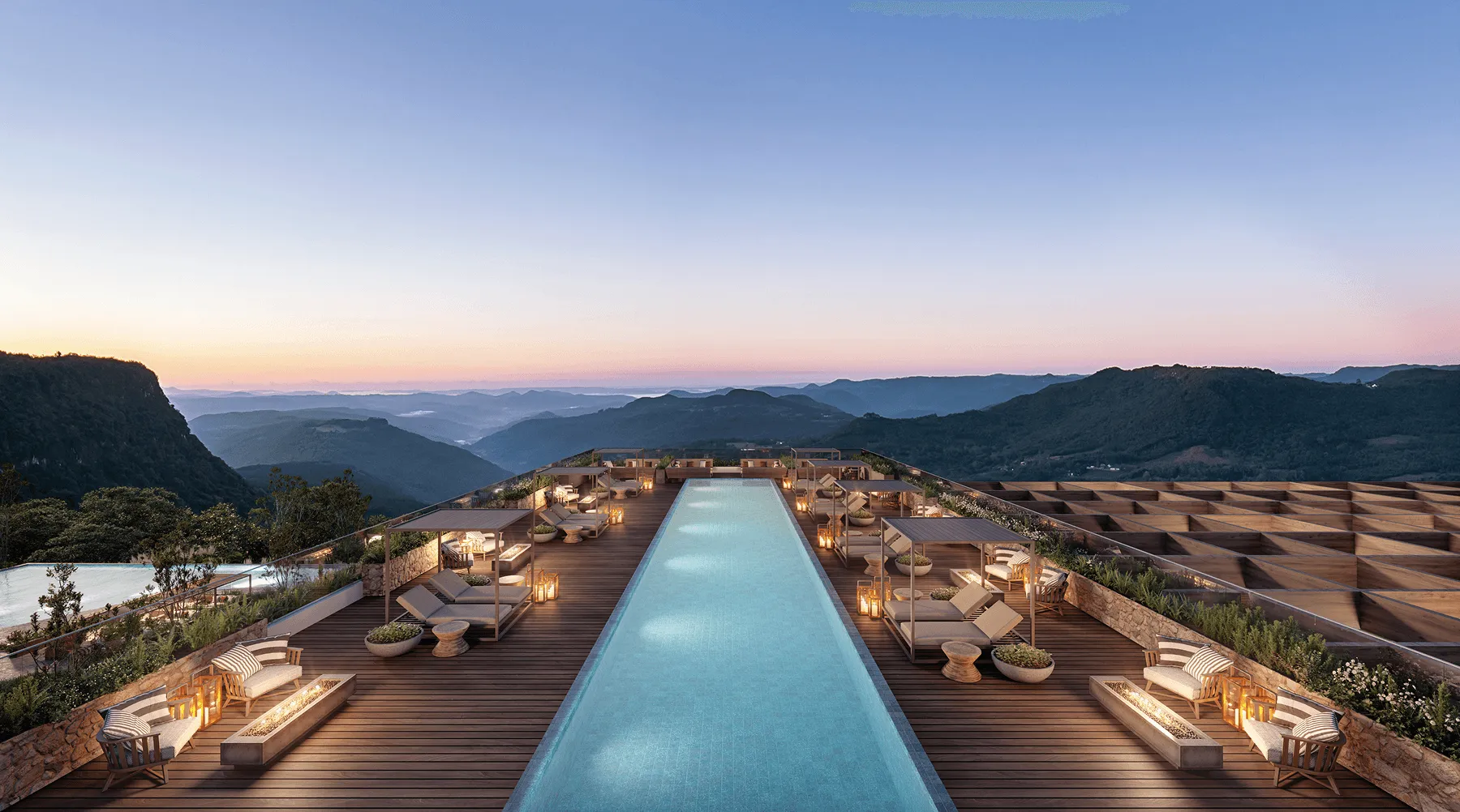 Piscina moderna e iluminada em deck de madeira com espreguiçadeiras e vista panorâmica de montanhas ao pôr do sol.