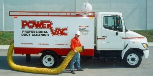 White Power Vac professional duct cleaning truck with a worker holding a yellow hose standing beside it.