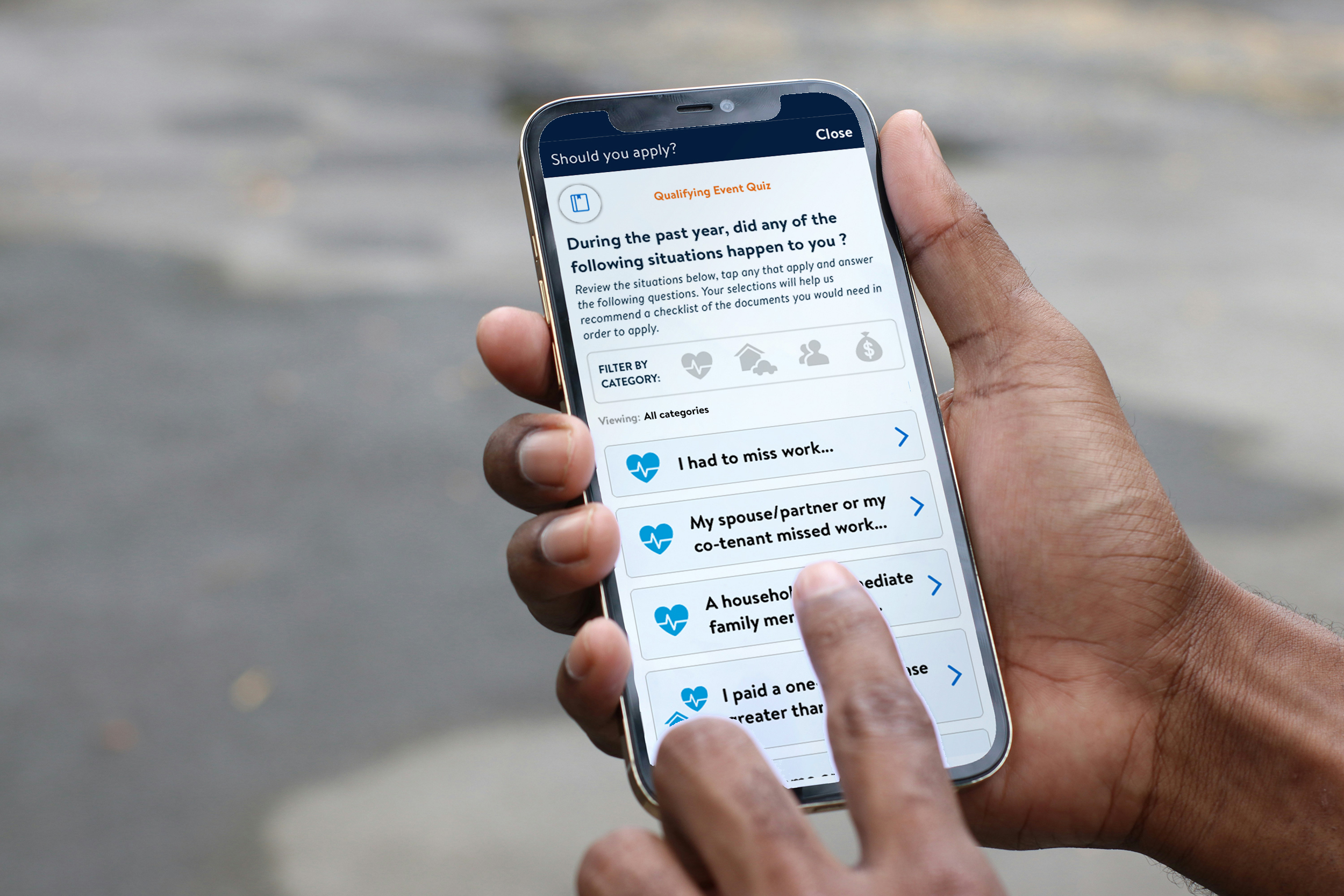 A view of an eligibility quiz on a handheld mobile device. The device user has dark skin tone and is tapping the screen. 
