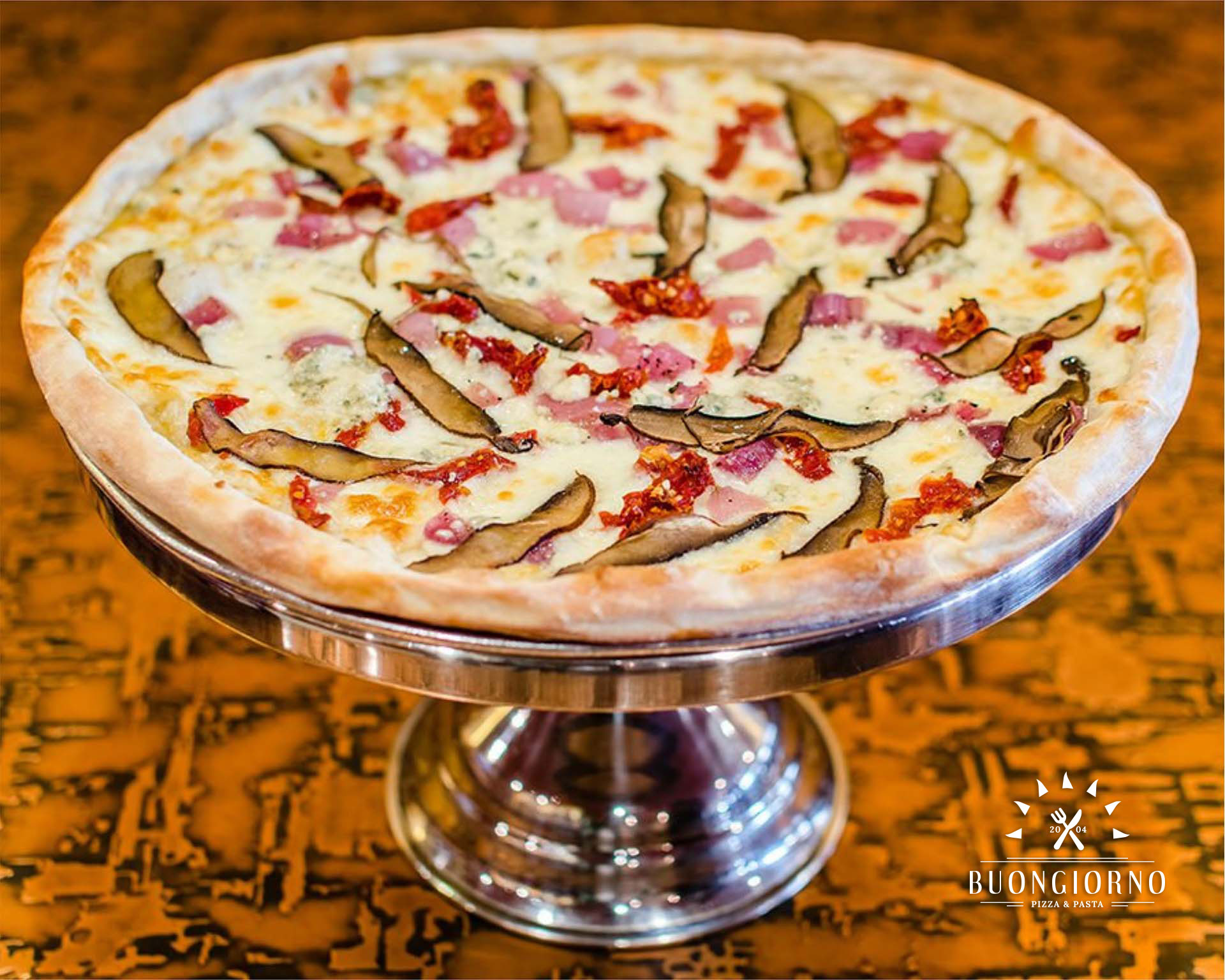 A pizza with mushrooms and ham on a silver platter.
