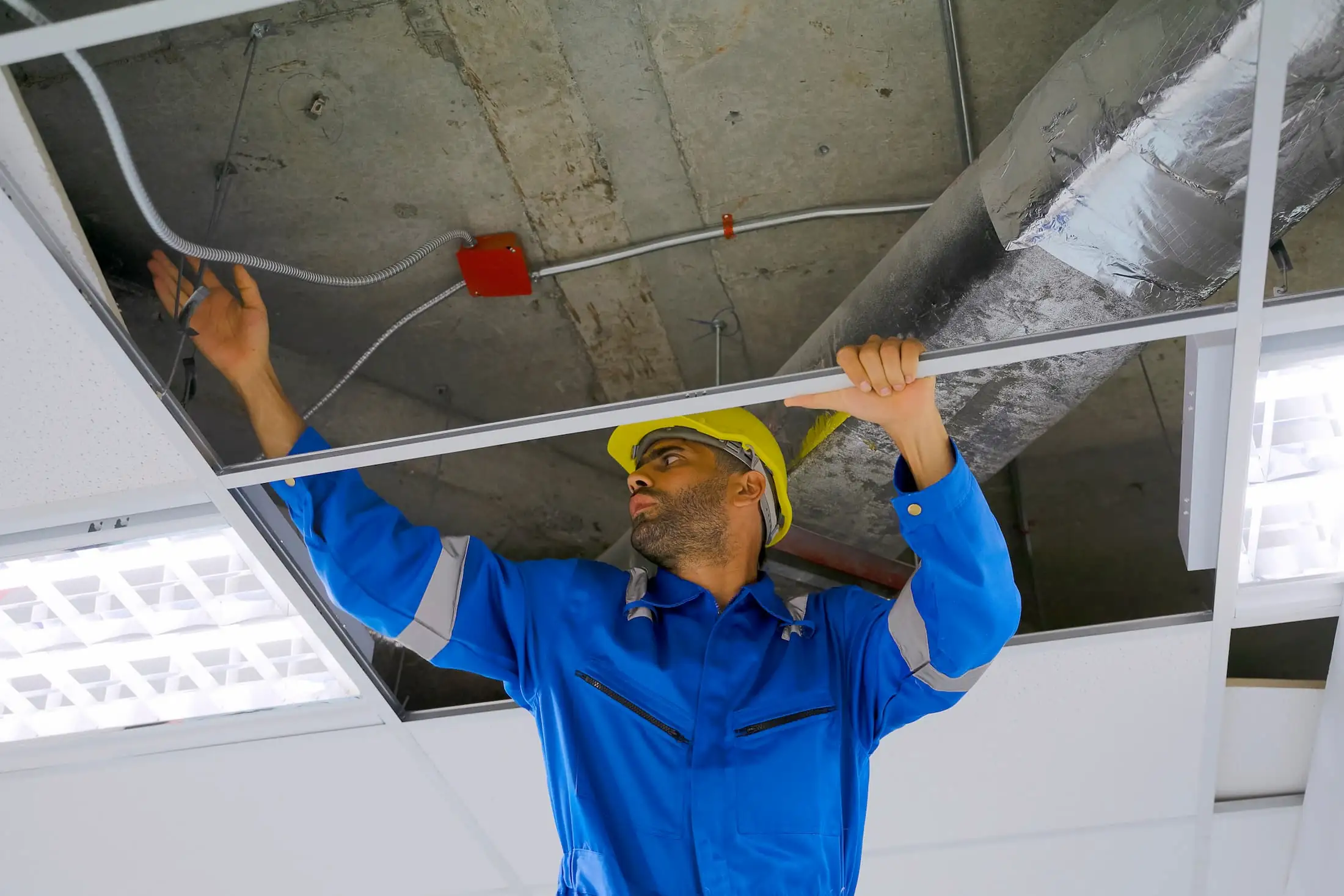 hvac maintenance working on commercial vent