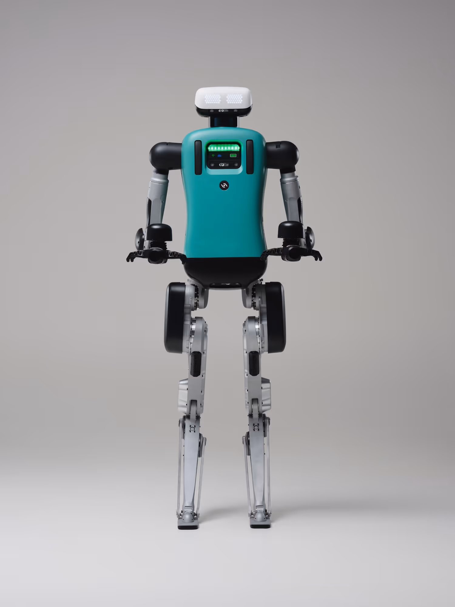 Humanoid robot with teal torso, white head, and metallic legs standing against a plain gray background.