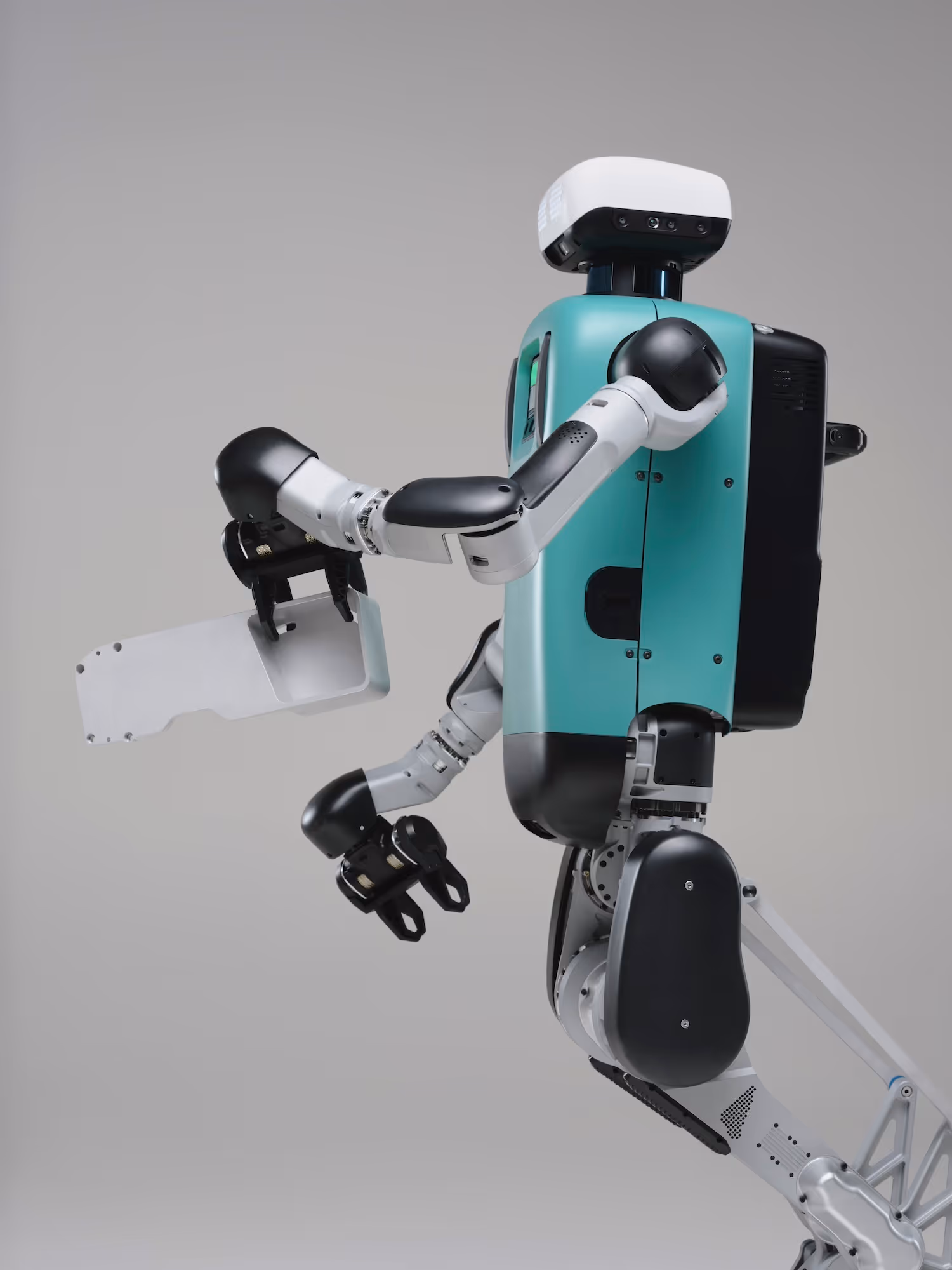 Agile humanoid robot with teal torso and articulated arms holding a metallic panel.