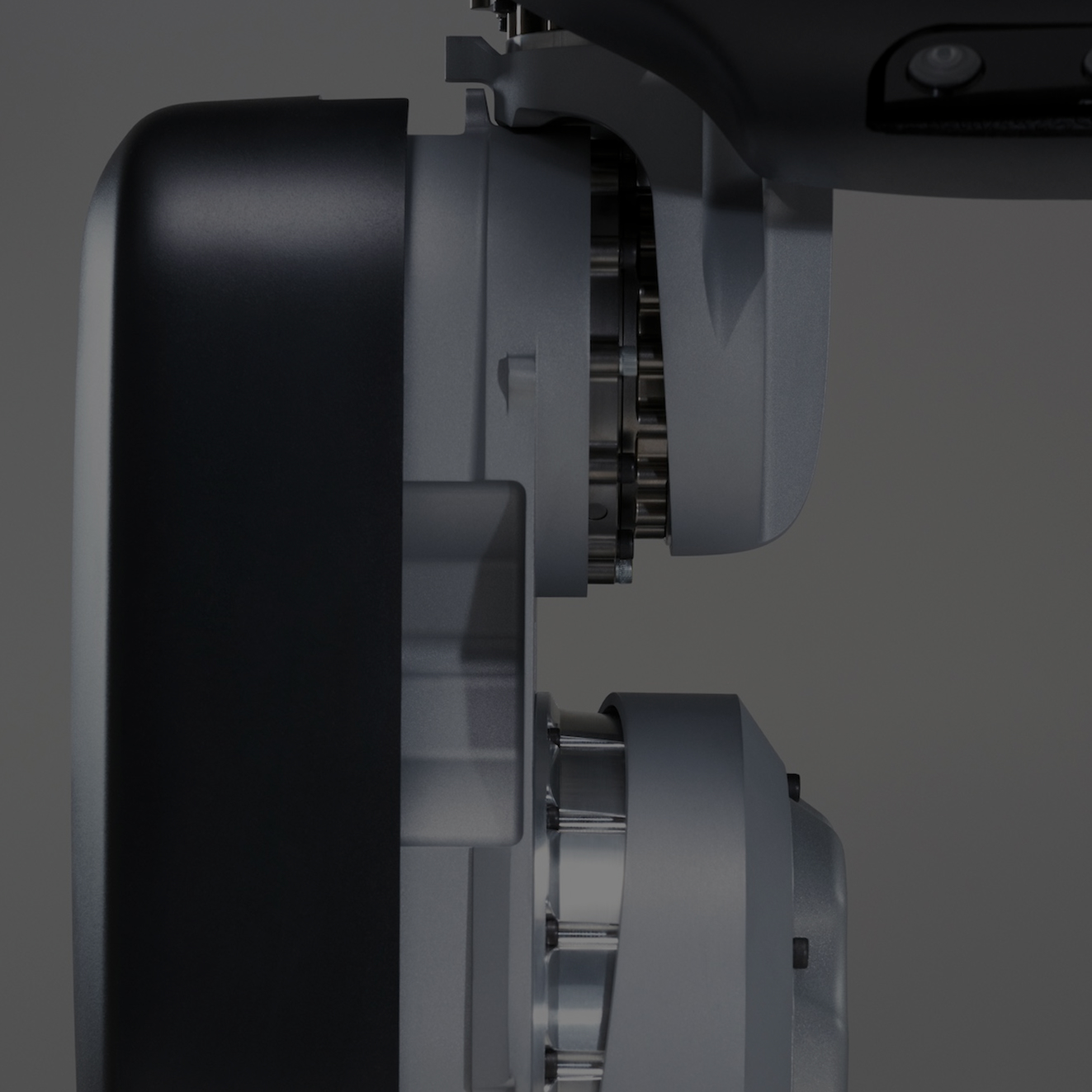 Close-up side view of a metallic mechanical component with gears and cylindrical parts.