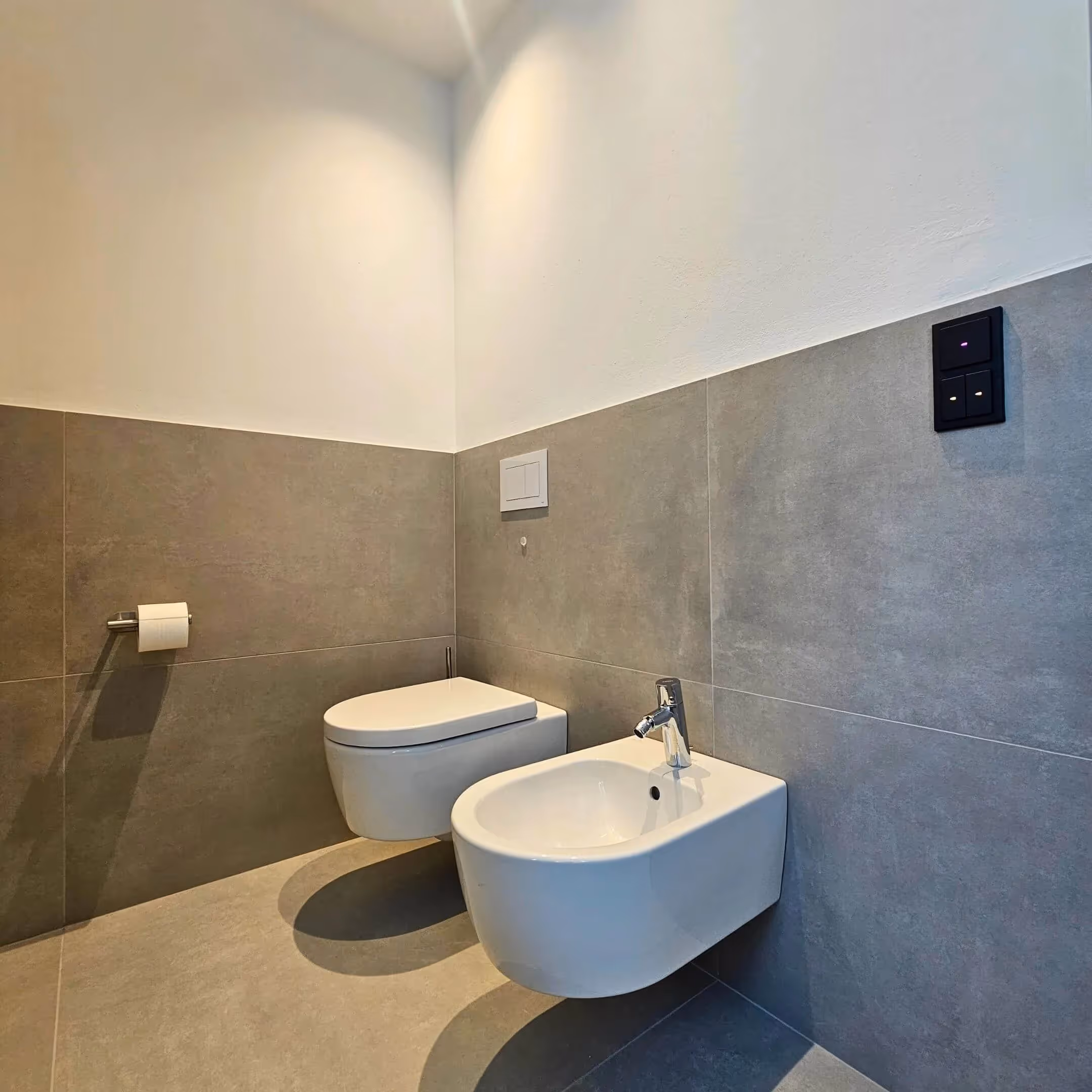 WC-Bereich mit dunklen Fliesen und klarer Linienführung