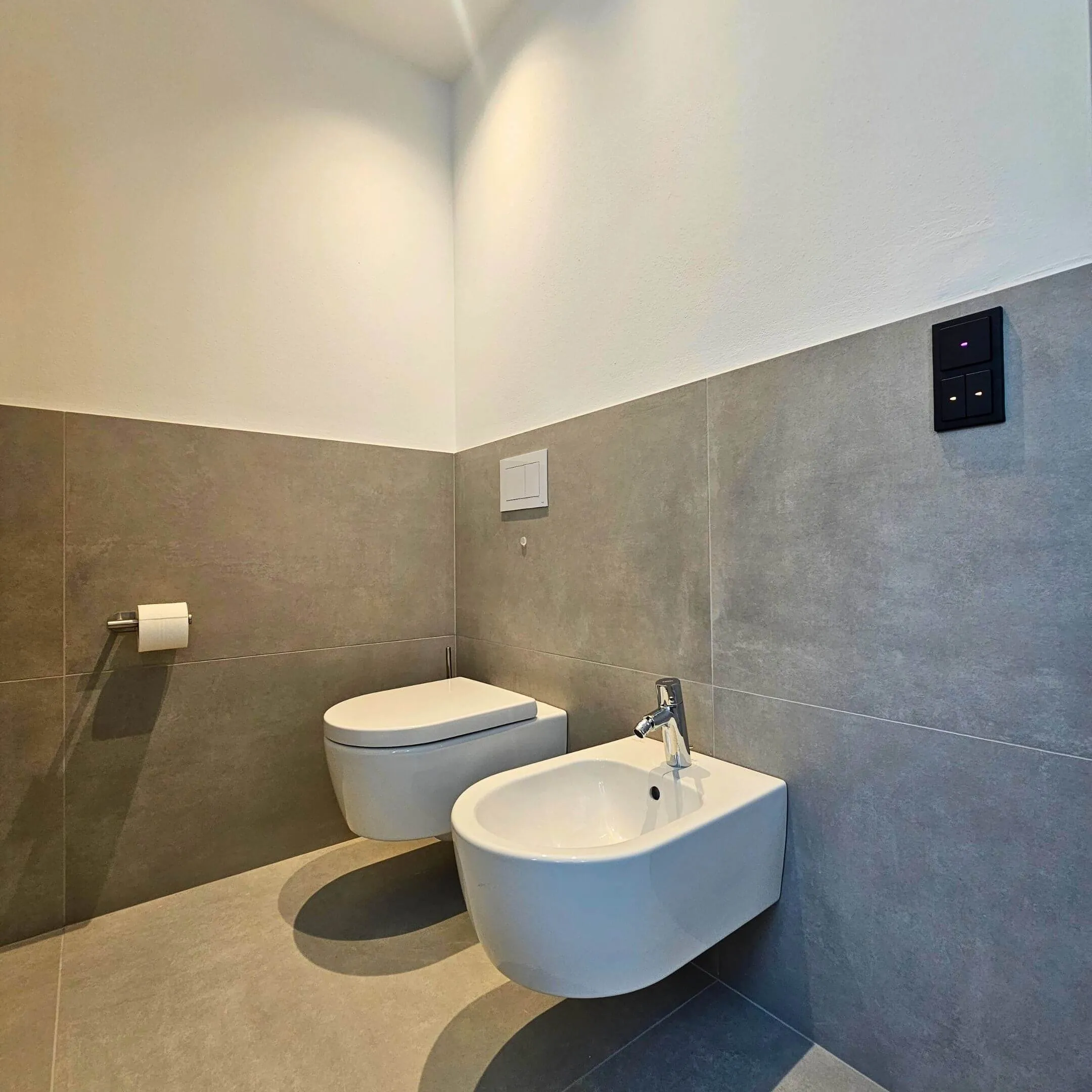 WC-Bereich mit dunklen Fliesen und klarer Linienführung