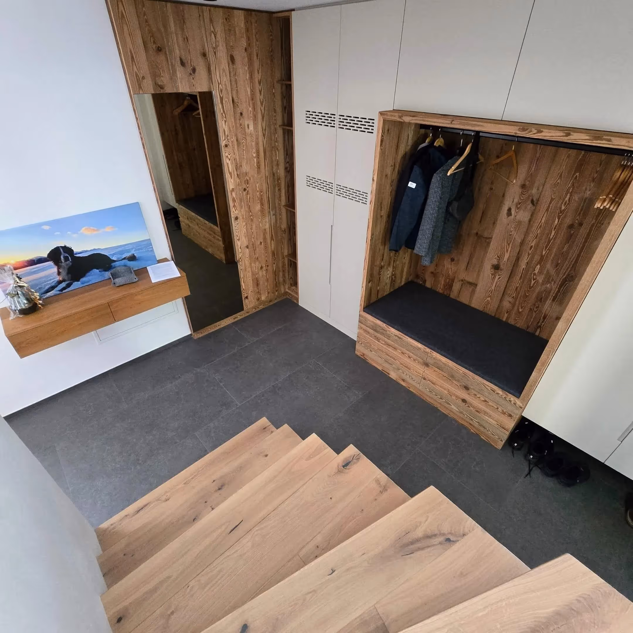 Eingangsbereich mit Fliesenboden und Holz-Treppenelement