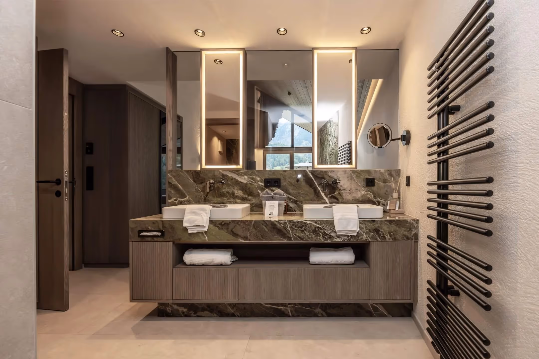 Badezimmer mit Feinsteinzeug-Fliesen und eleganter Beleuchtung