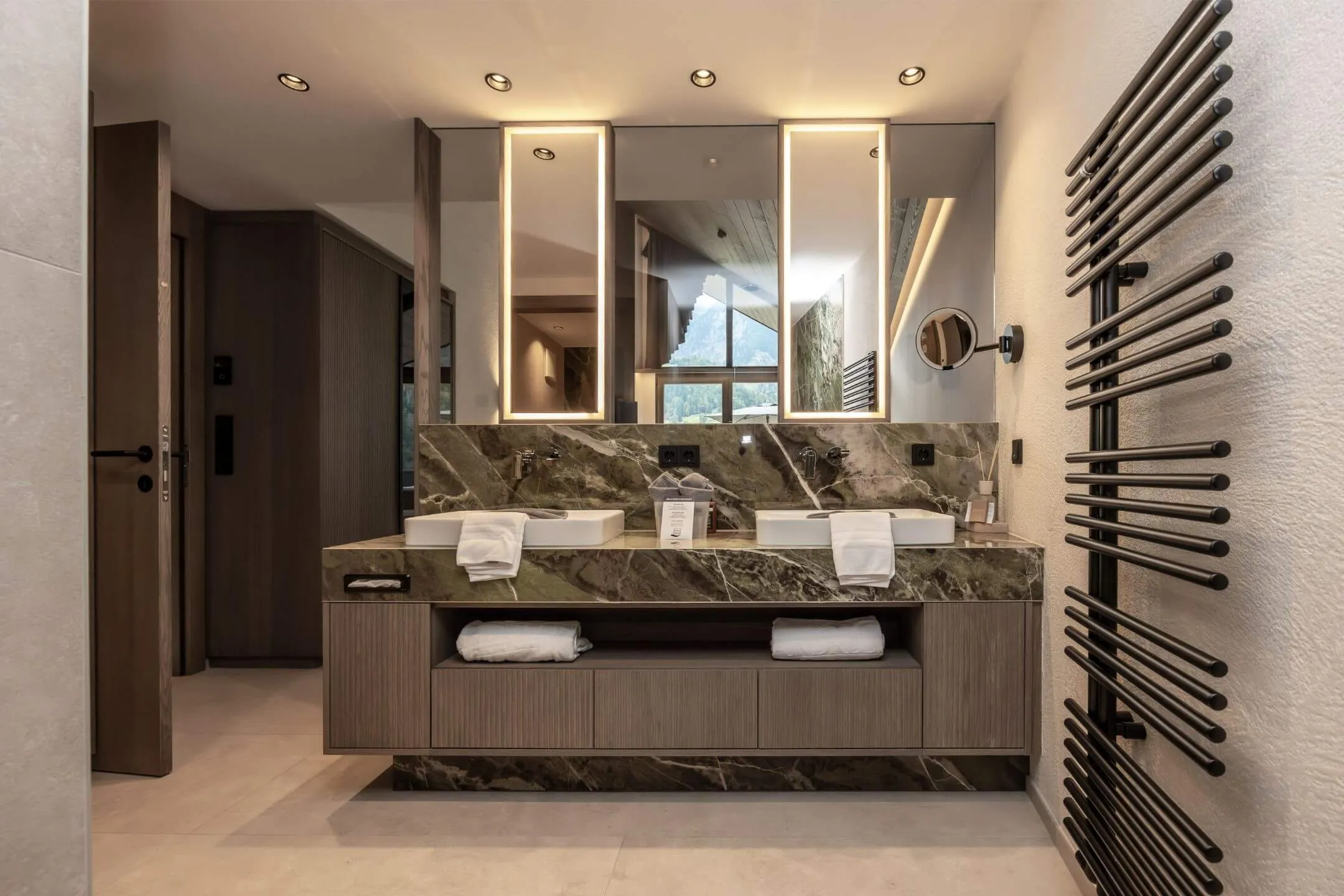 Badezimmer mit Feinsteinzeug-Fliesen und eleganter Beleuchtung