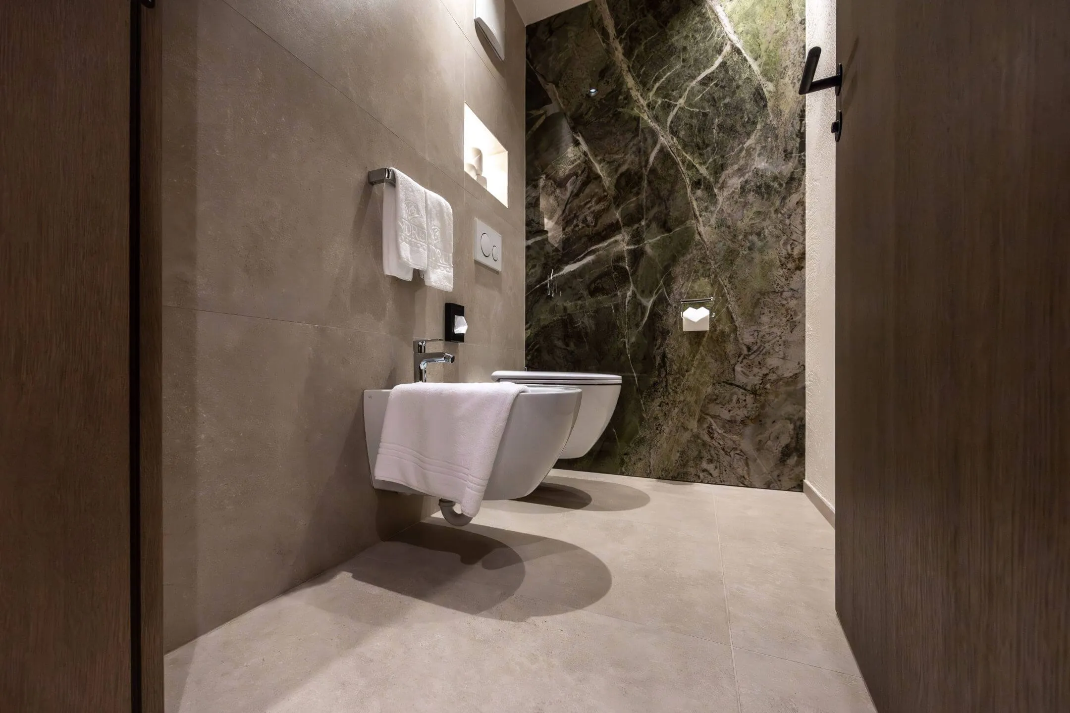 Gäste-WC mit dunklen Wandfliesen und integriertem Waschtisch