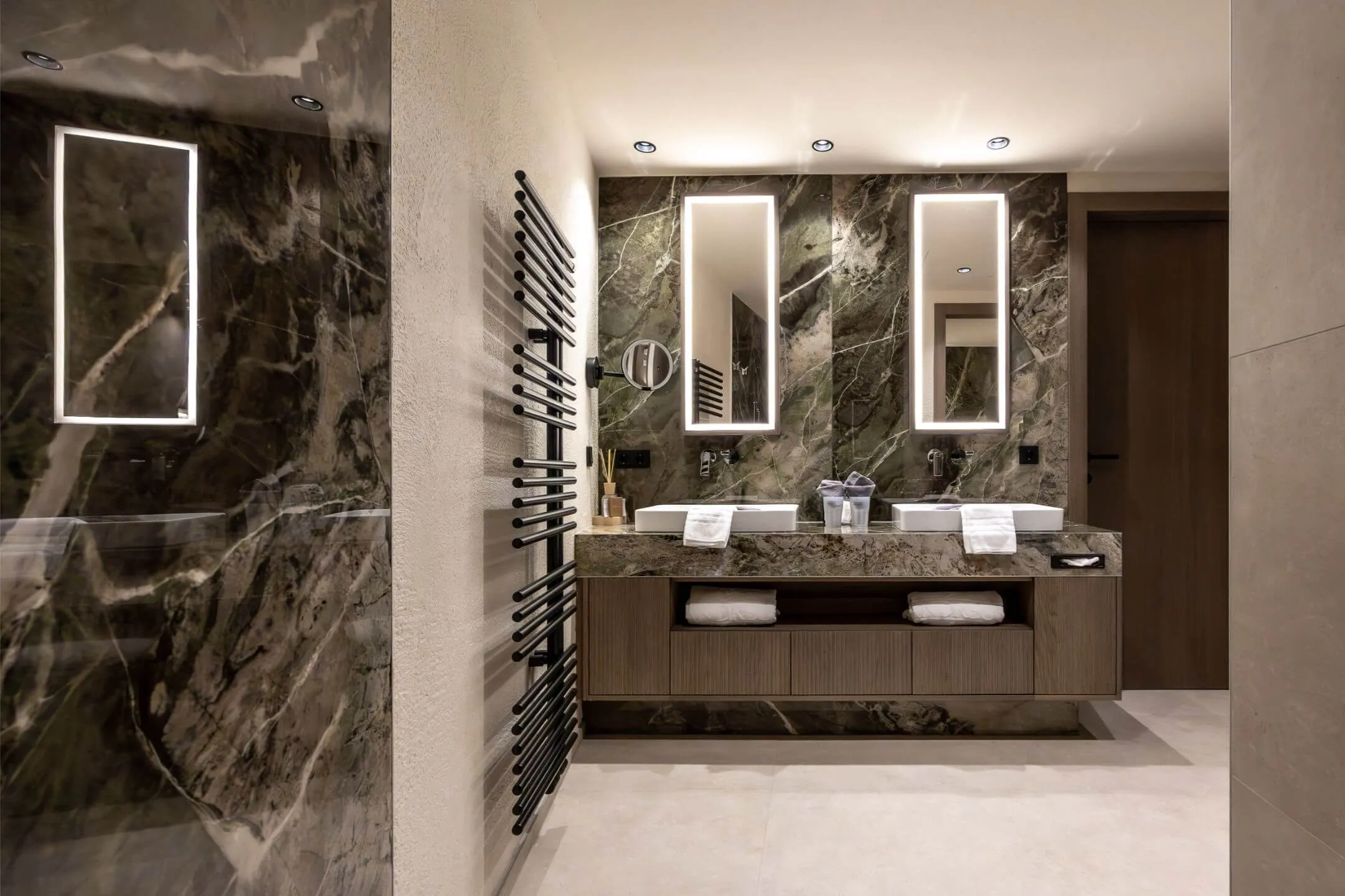 Badezimmer mit großformatigen Wandfliesen und Holz-Akzenten