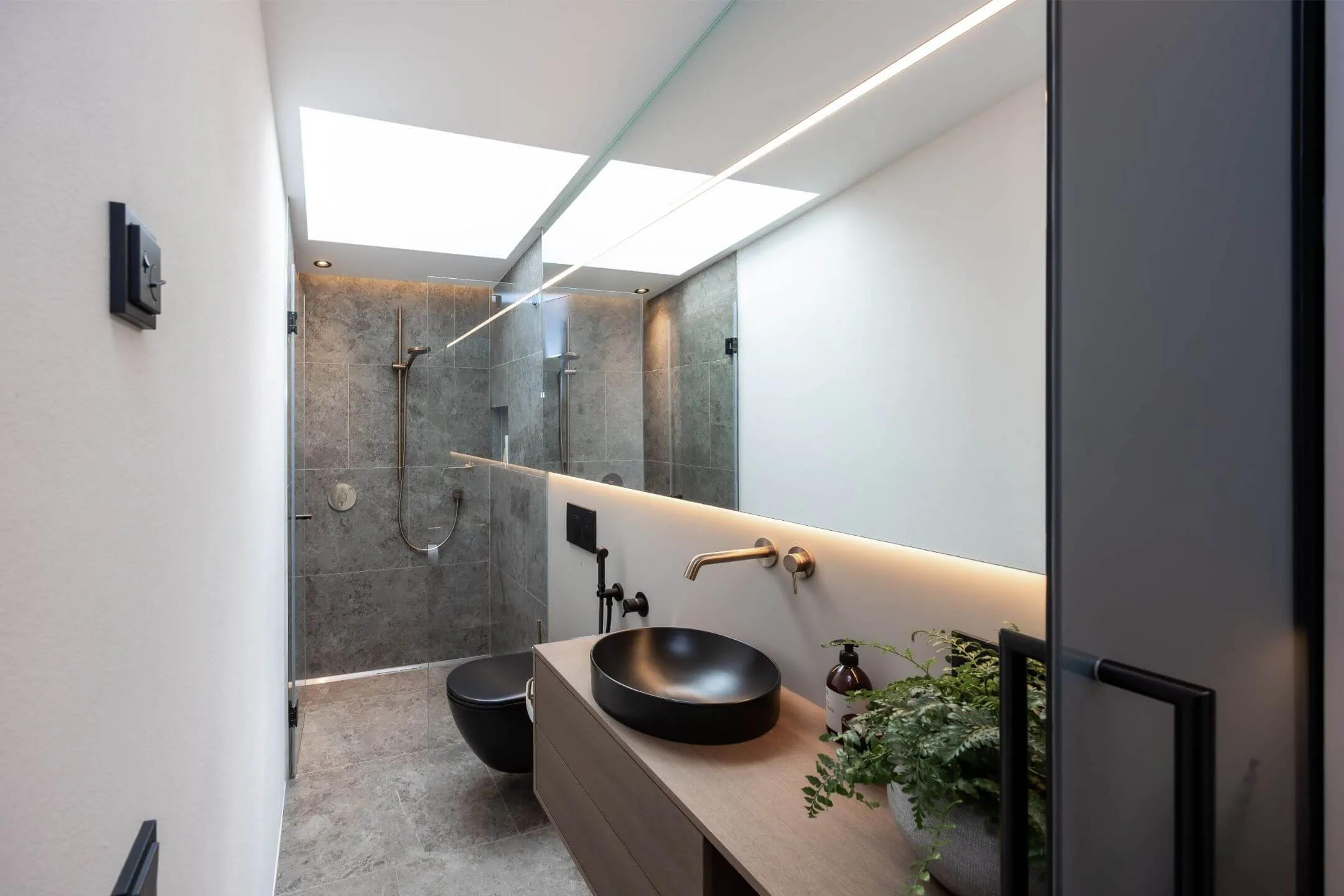 Badezimmer mit wandbündigen Fliesen und minimalistischer Waschtischlösung