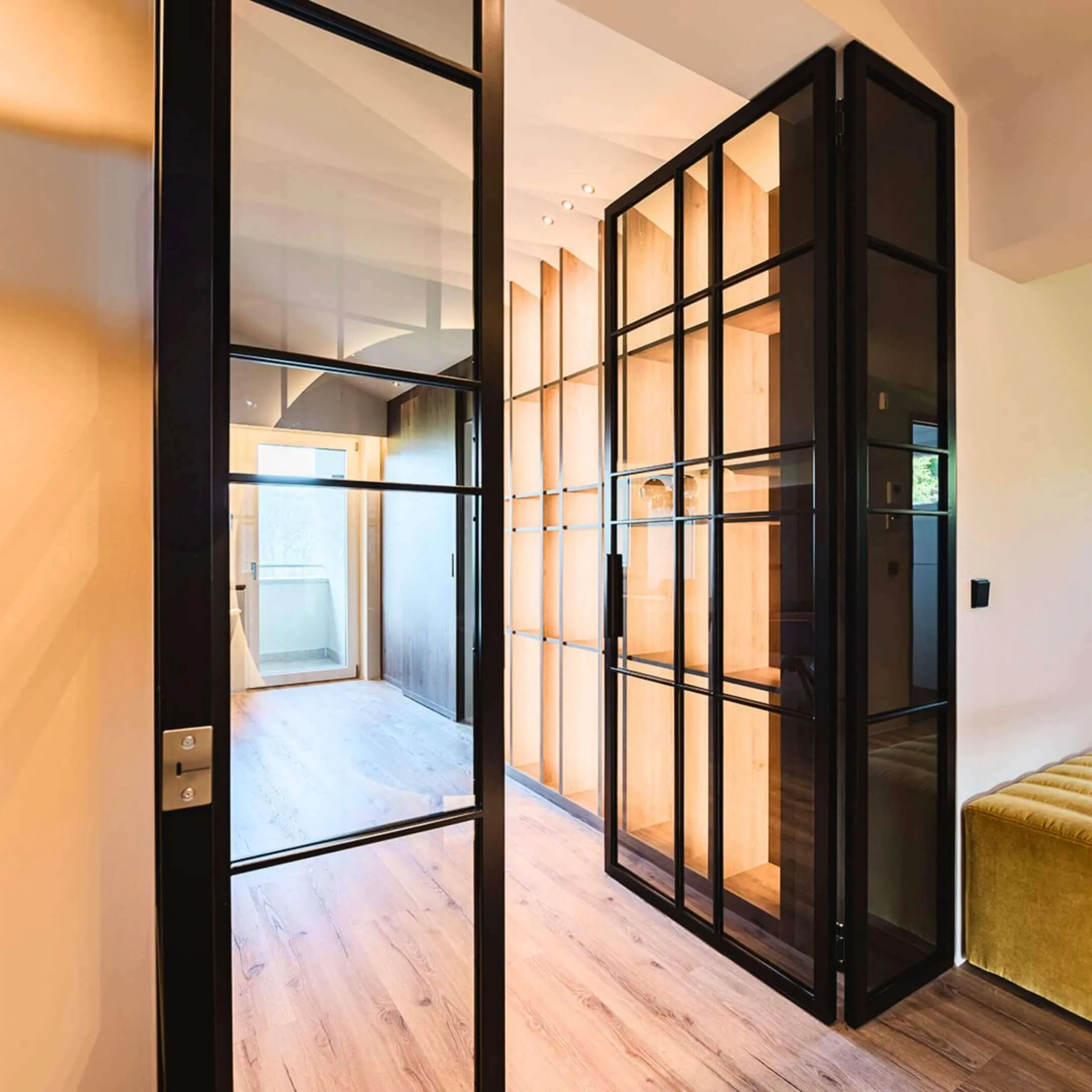 Offener Raum mit Designboden und schwarzer Glas-Metall-Trennwand