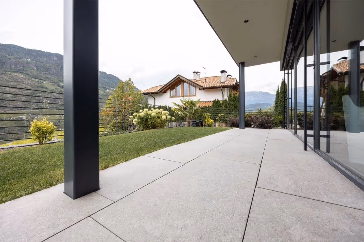 Überdachter Terrassenbereich mit großformatigen Fliesen