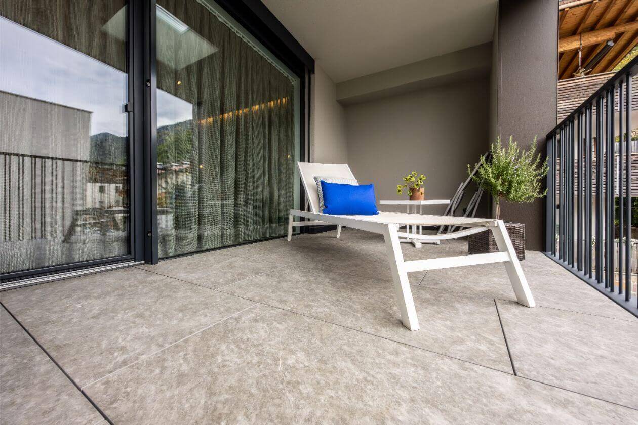 Terrasse mit Outdoor-Fliesen und moderner Sitzgelegenheit