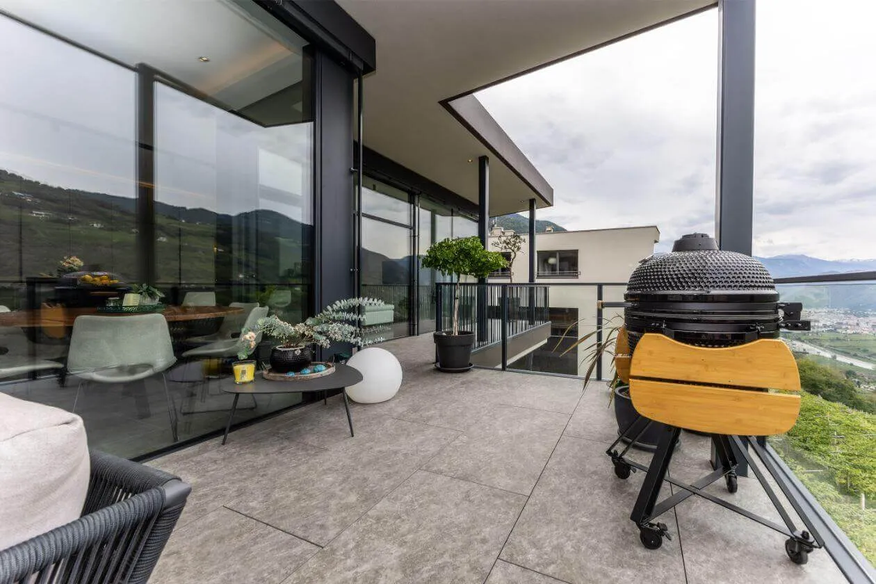 Überdachter Außenbereich mit großformatigen Terrassenfliesen und Grill
