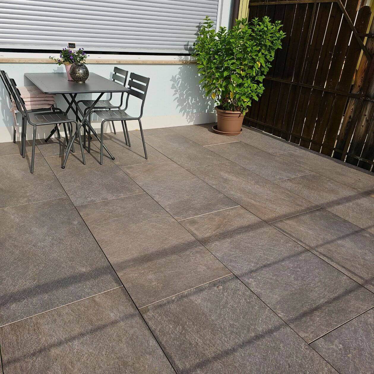 Terrasse mit großformatigen Fliesen und Sitzbereich