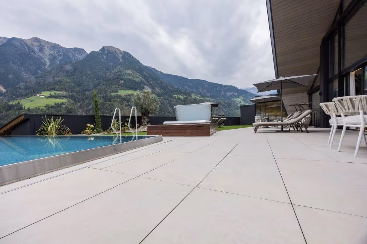 Großzügige Terrasse mit hellen Fliesen und Blick auf die Berge