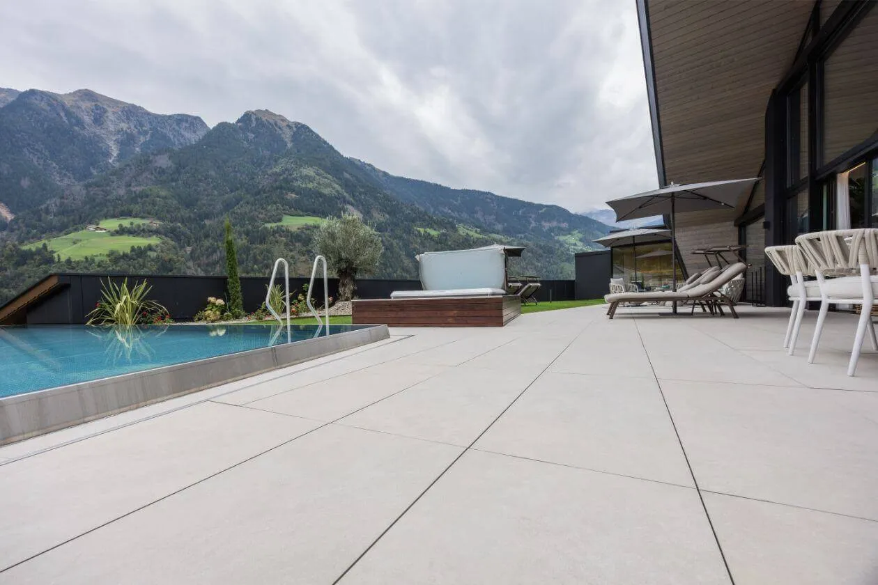 Großzügige Terrasse mit hellen Fliesen und Blick auf die Berge