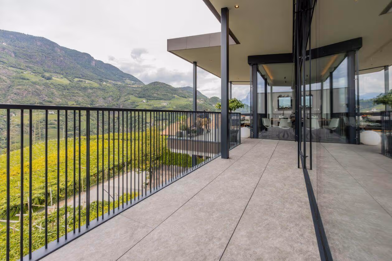 Balkon mit langlebigen Bodenfliesen und schwarzem Metallgeländer