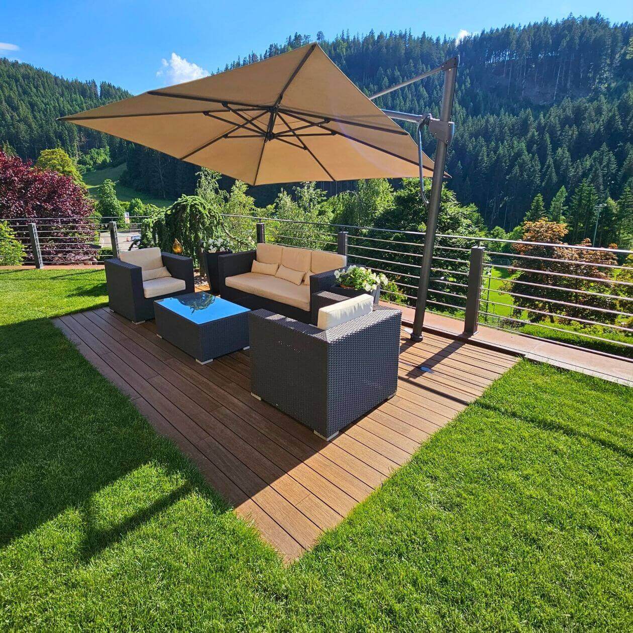 Terrasse mit Outdoor-Fliesen und Lounge-Möbeln im alpinen Garten