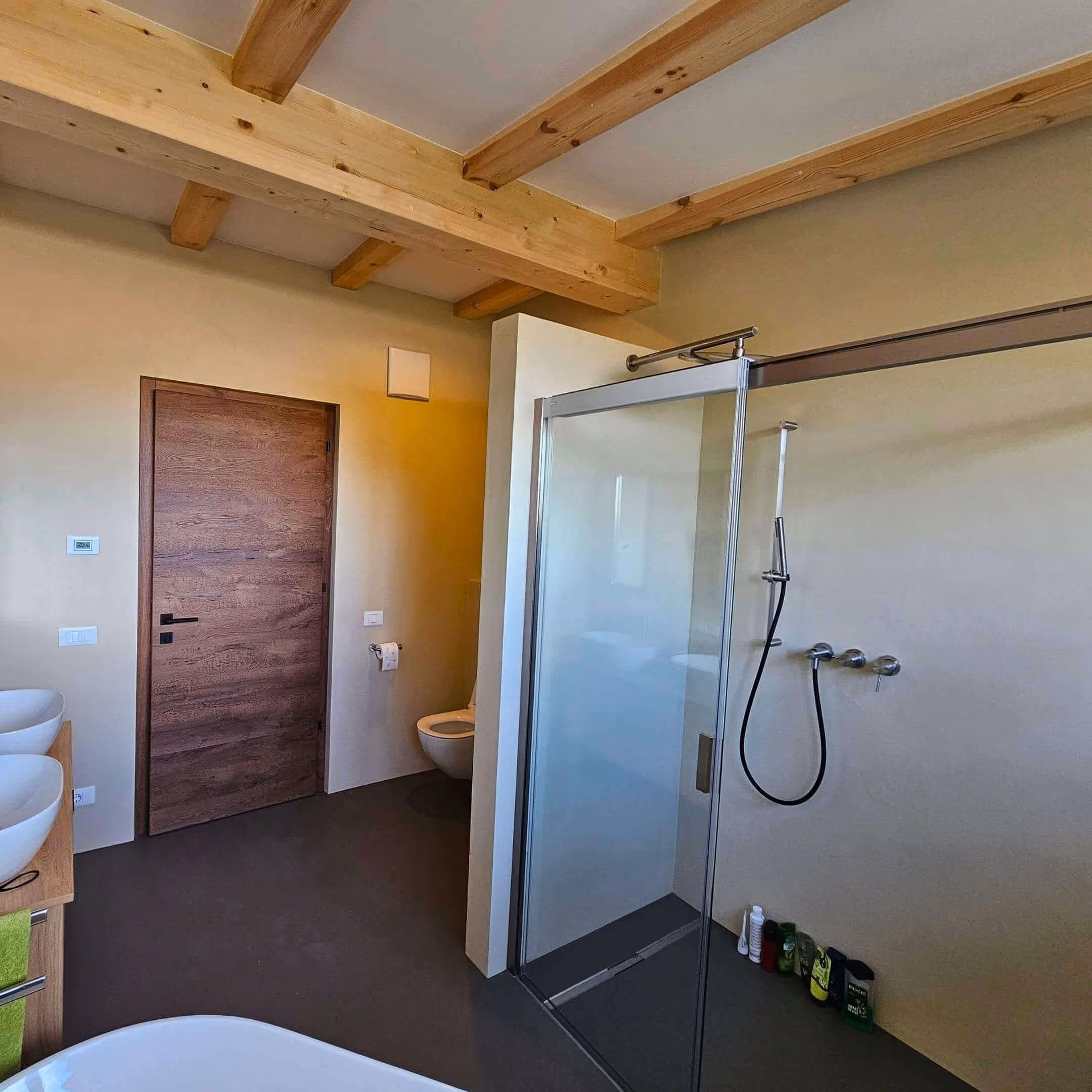 Badezimmer mit fugenloser Wandbeschichtung und Holzdecke